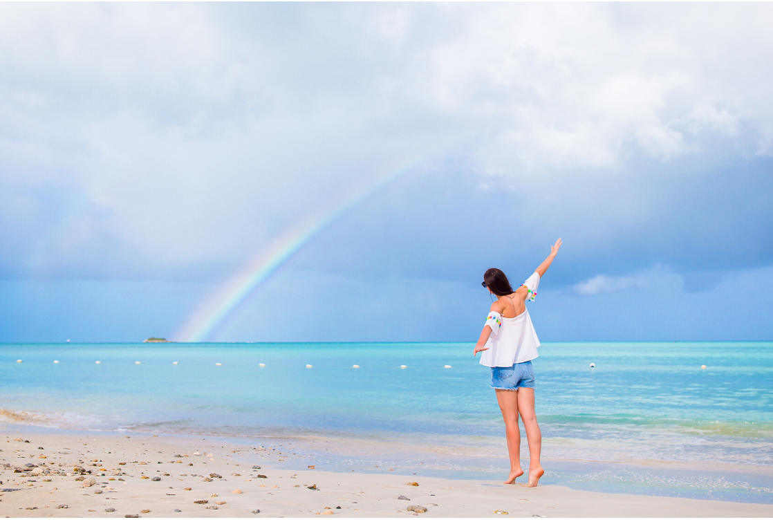 lady on beach with rainbow