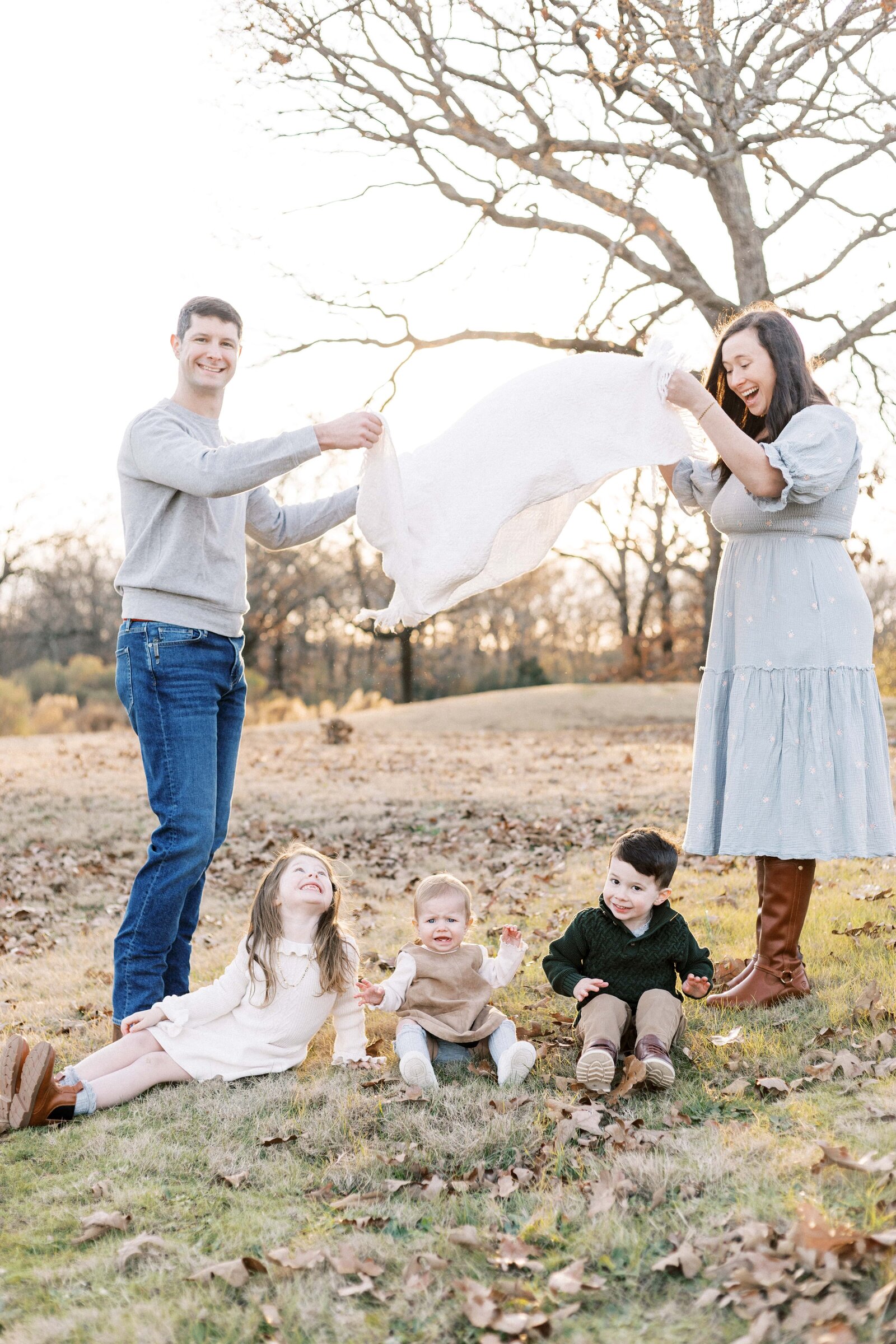 kids playing under blanket during sunset family photos in peoria illinois 