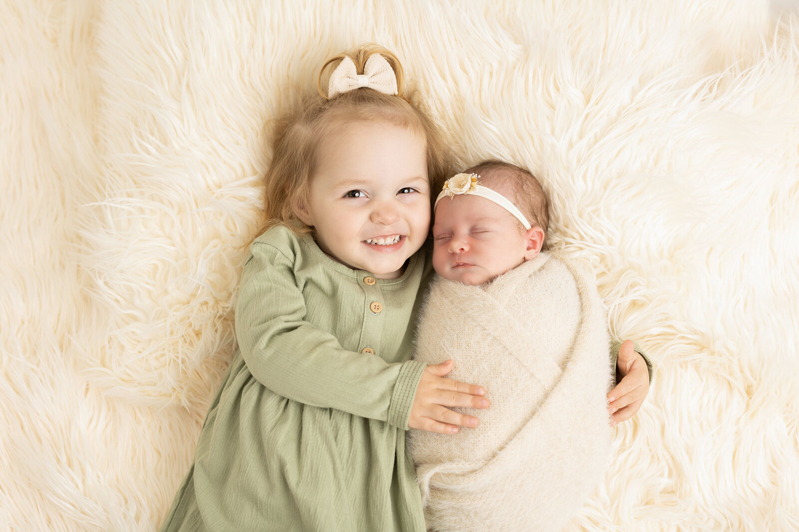 sister laying down with her brand new baby sister