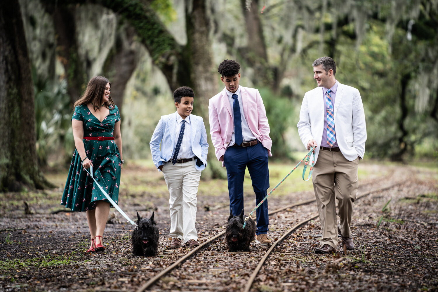 Family portrait walking along kiddie railroad tracks in City Park