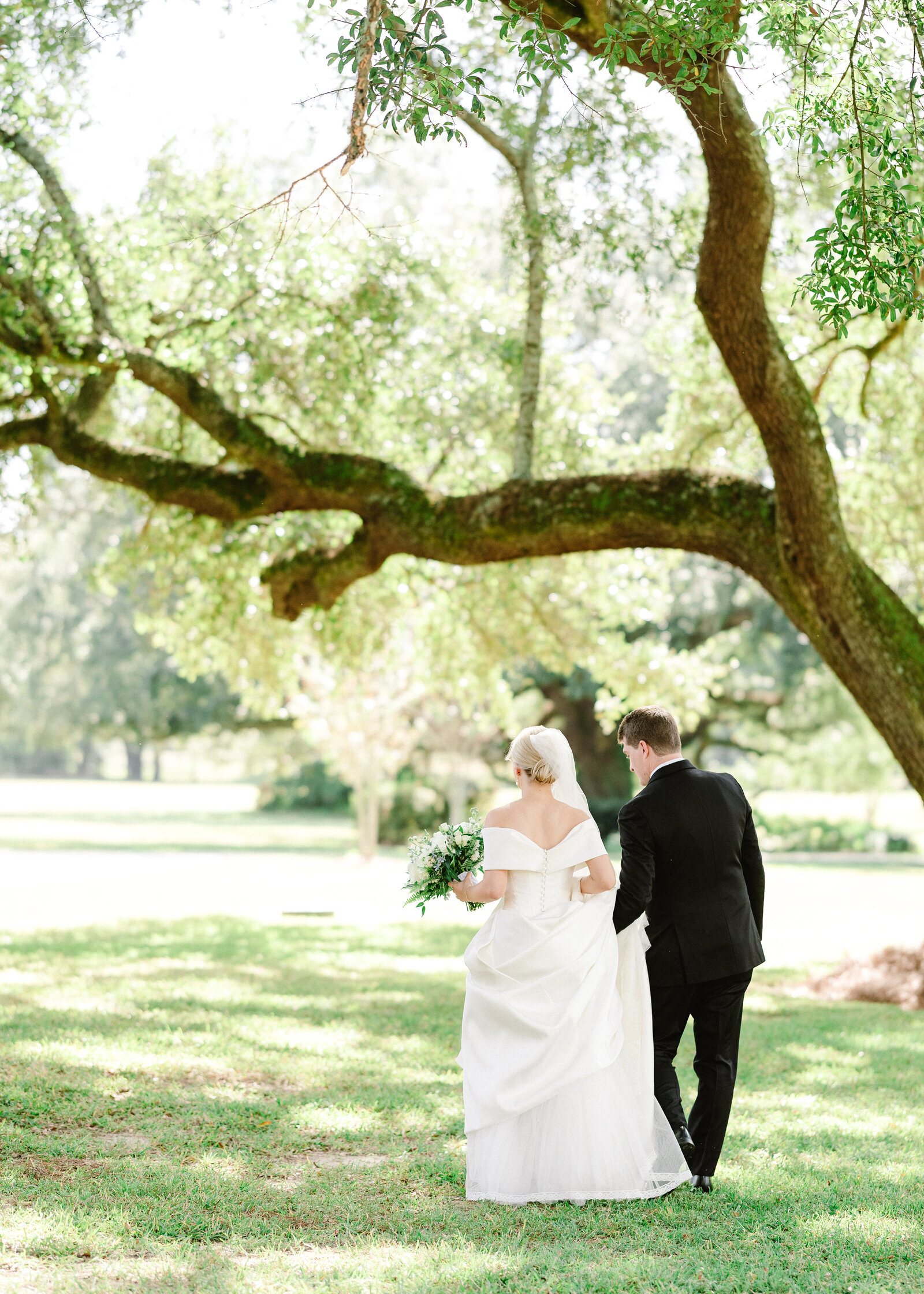 Mallory and Jack’s candid wedding photo under a scenic tree, photographed by a fine art wedding photographer in Alabama.