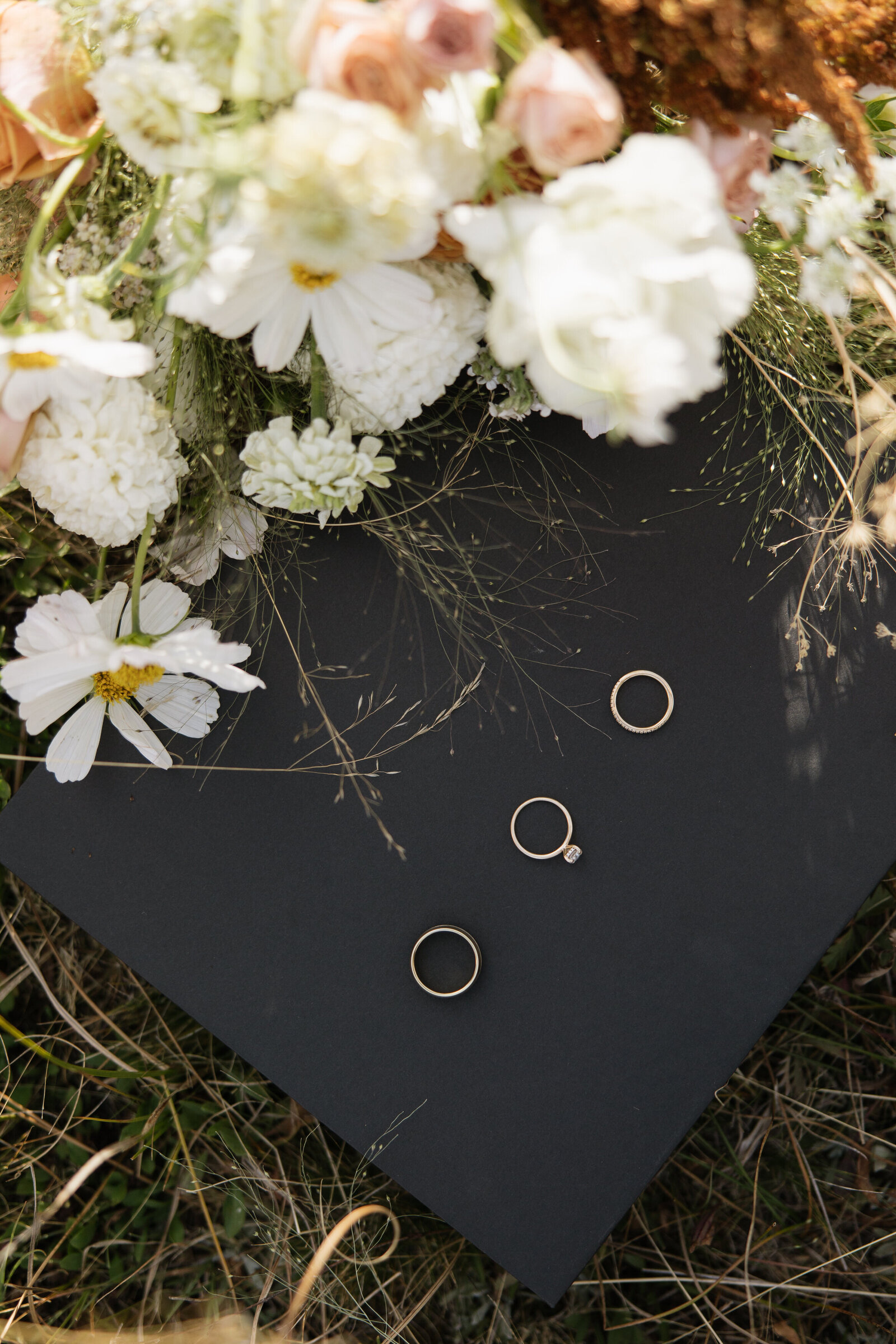 Flatlay with rings, florals, and vow books at a mountain wedding near Stanley, Idaho