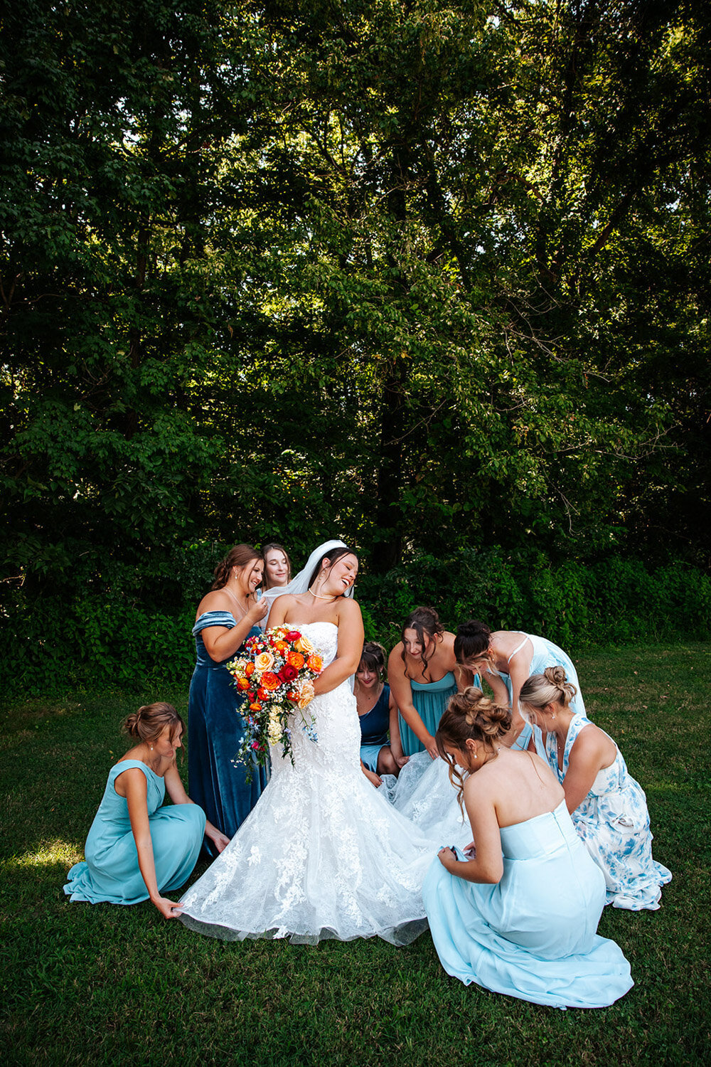Bridesmaids perfecting brides gown