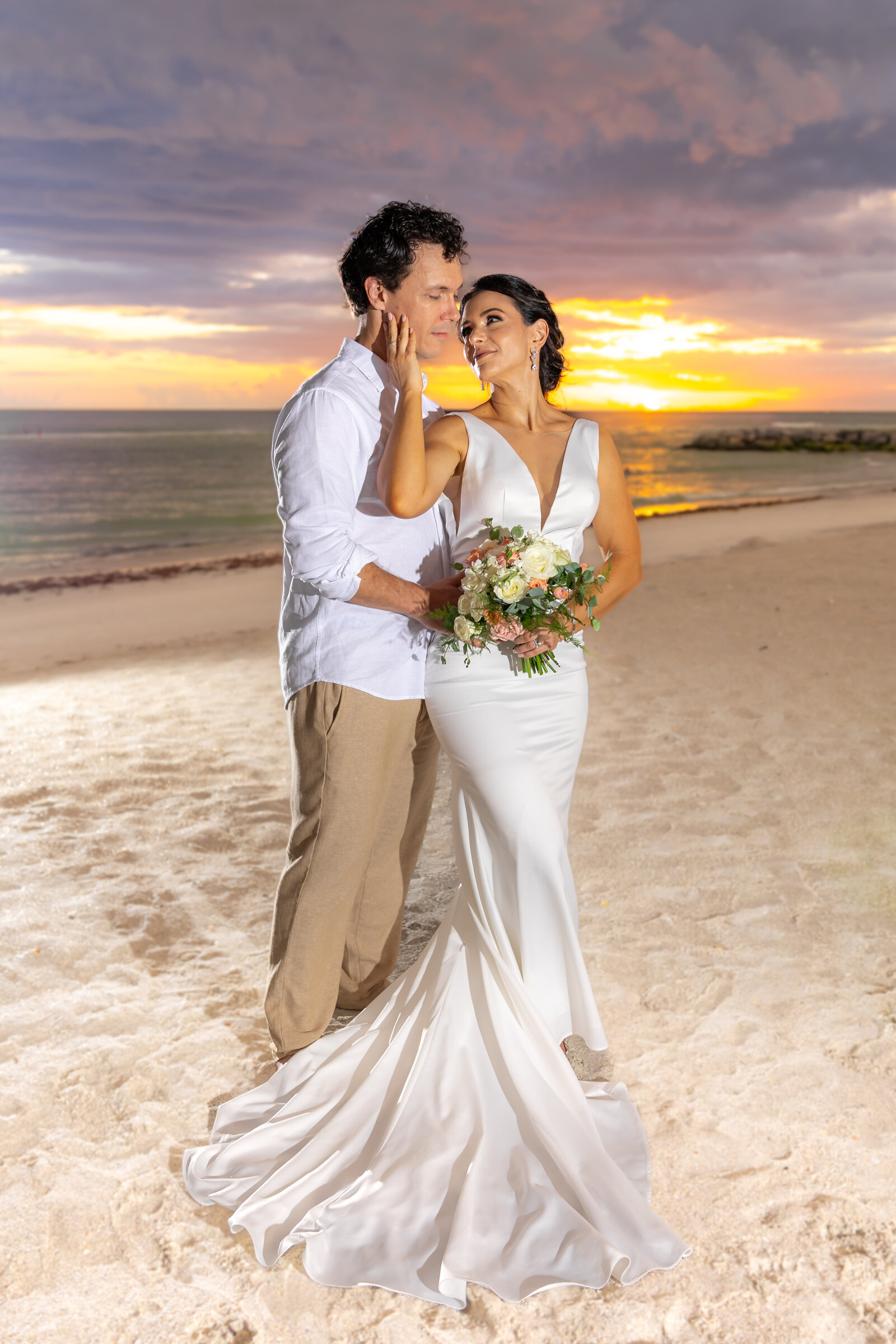 Bride and groom embracing on Lido beach at sunset after their Sarasota Wedding ceremony