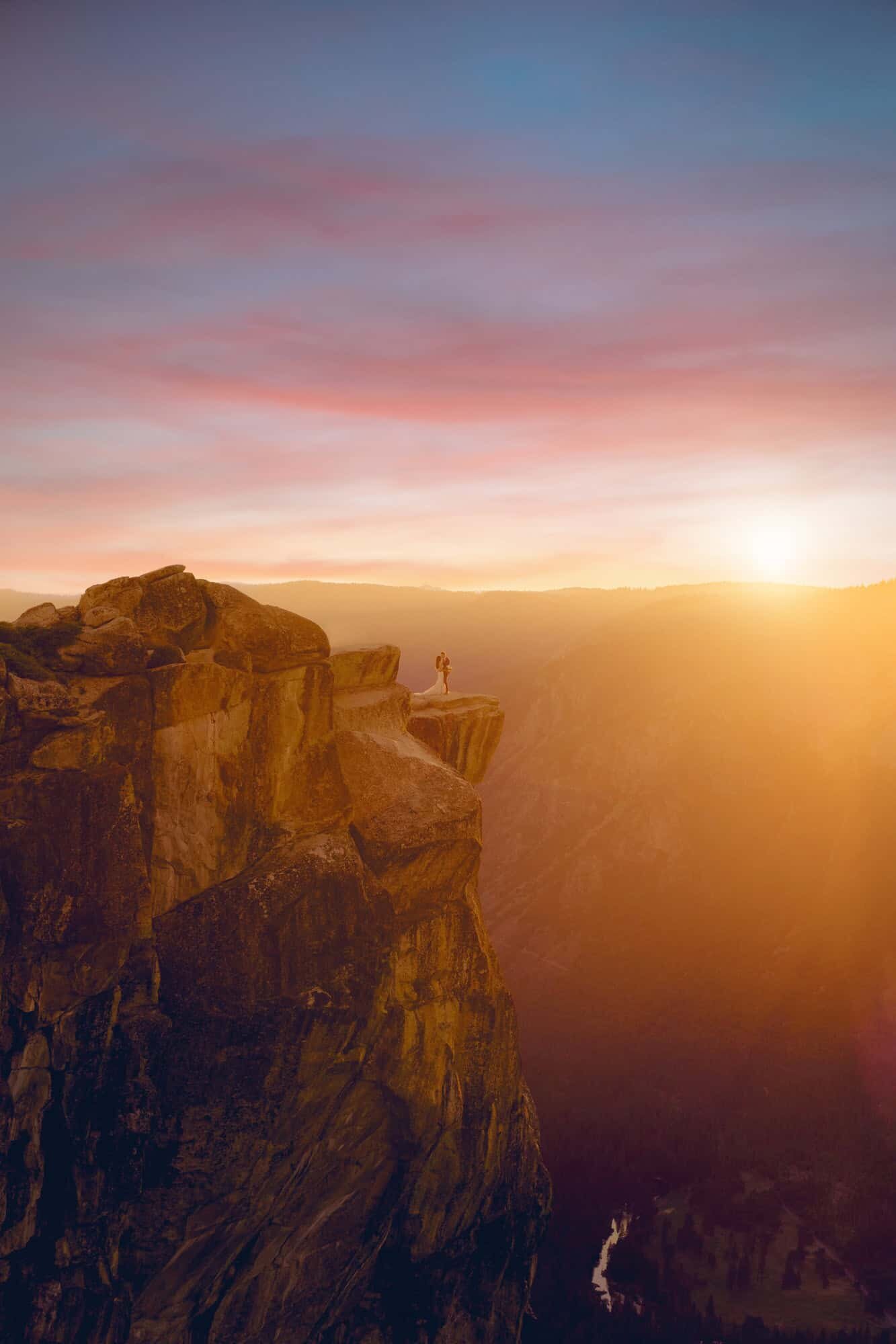 A bride and groom enjoy a sunset on their Yosemite Elopement day from the epic view at Taft Point in Yosemite National Park.