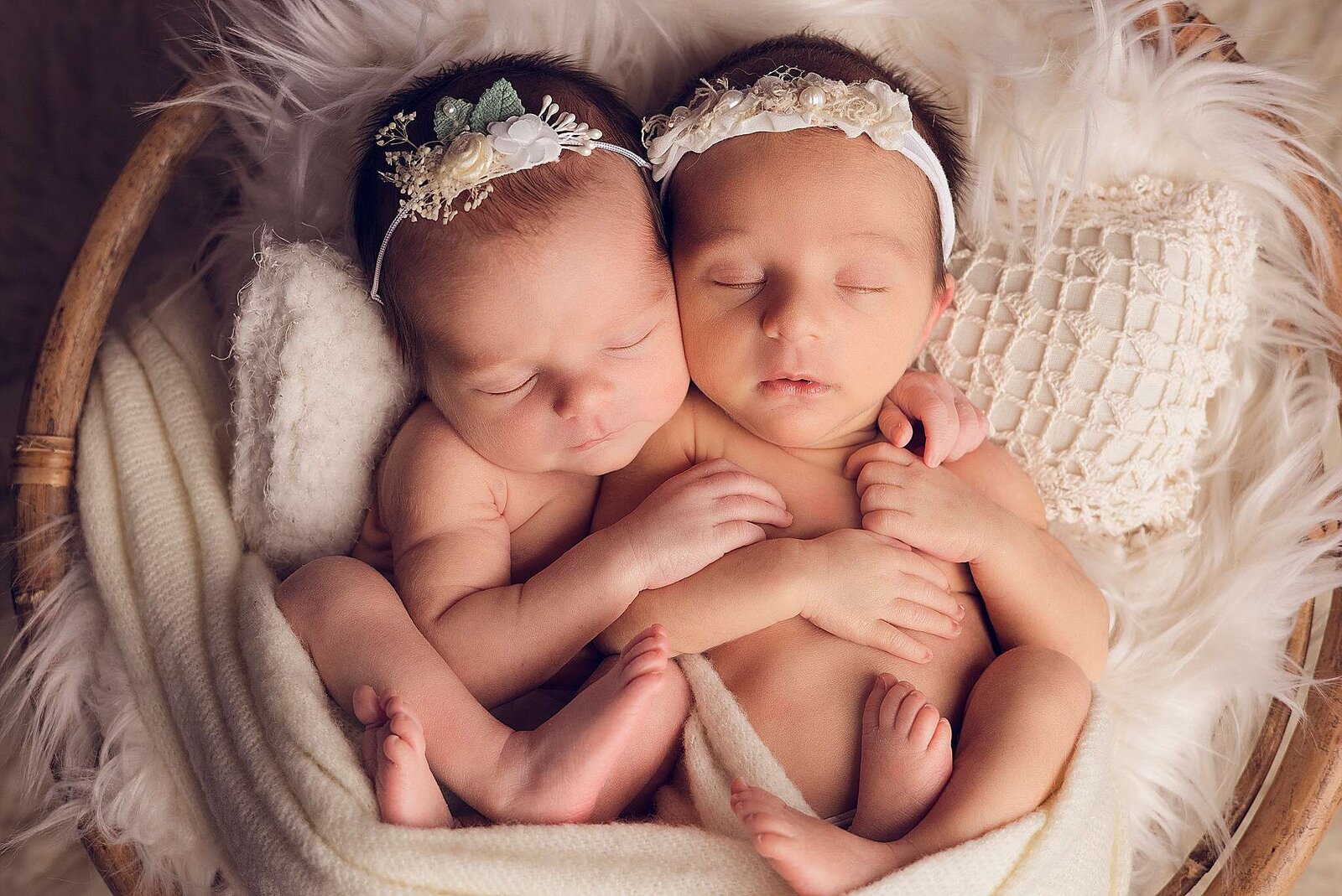 Two peaceful newborn twins nestled together in a basket, captured by Bia Schaefer, Orlando's expert newborn photographer.