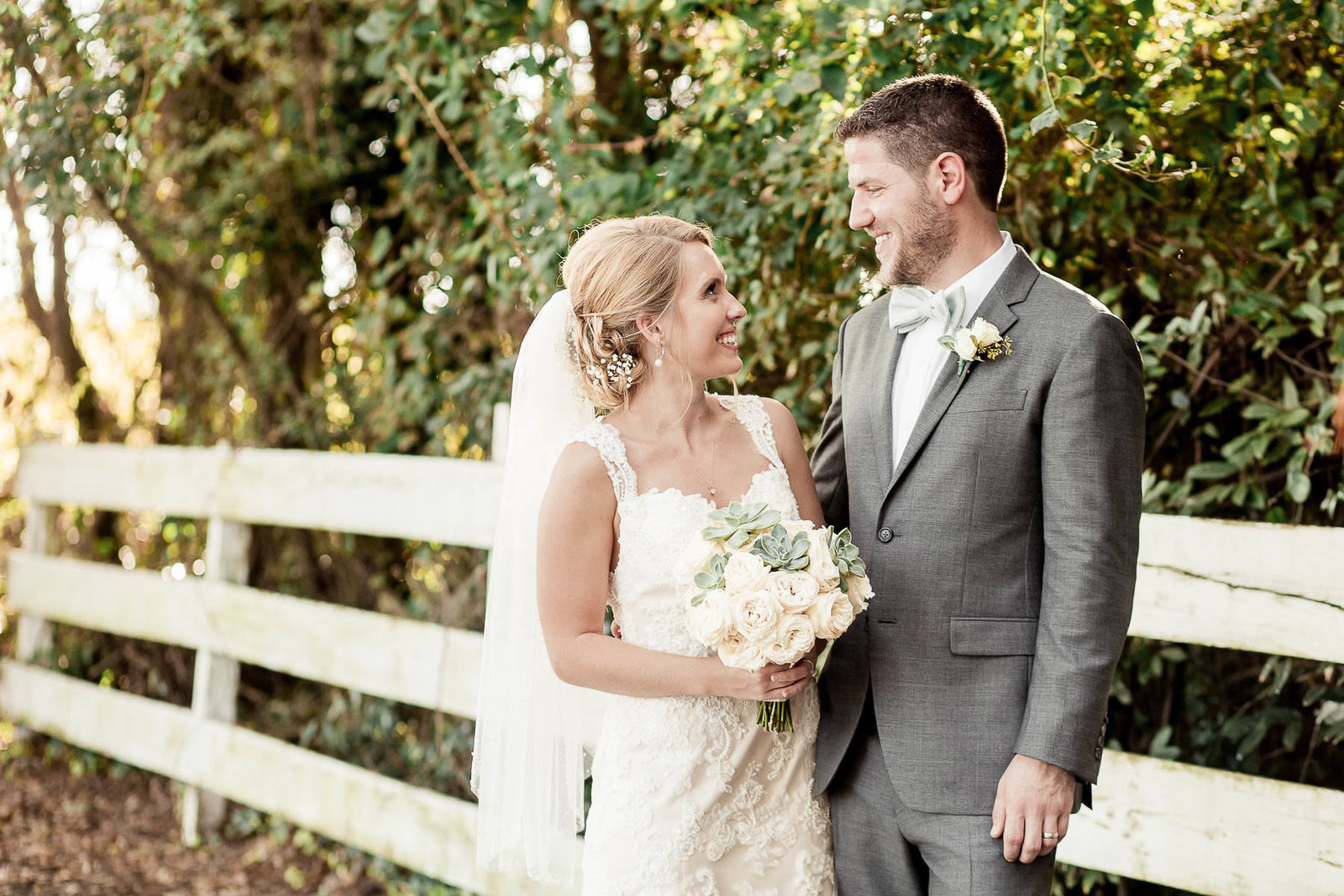 Bride and groom stand by white picket fence, Alhambra Hall, Mt Pleasant, South Carolina