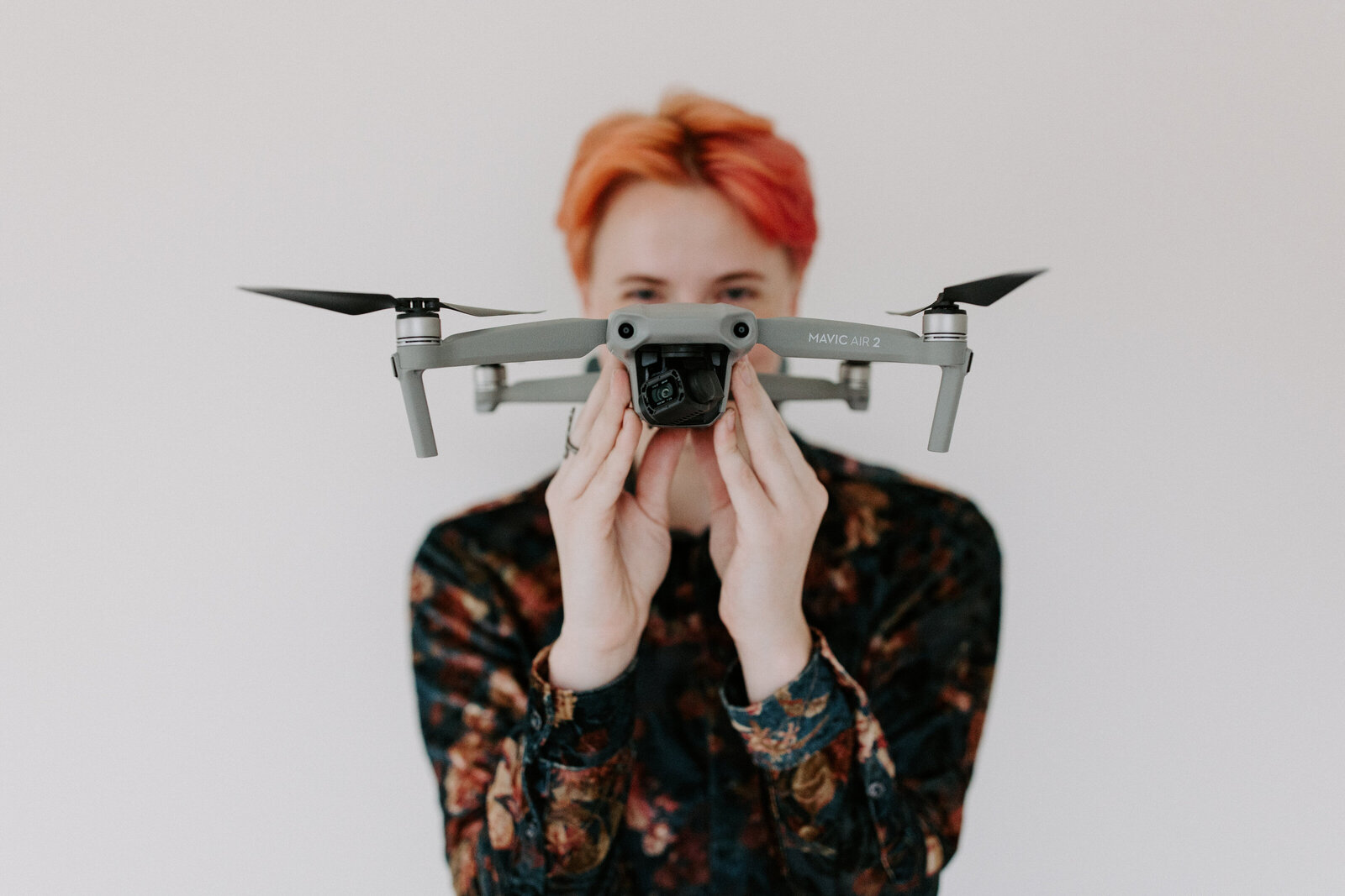 person holding a drone in front of their face