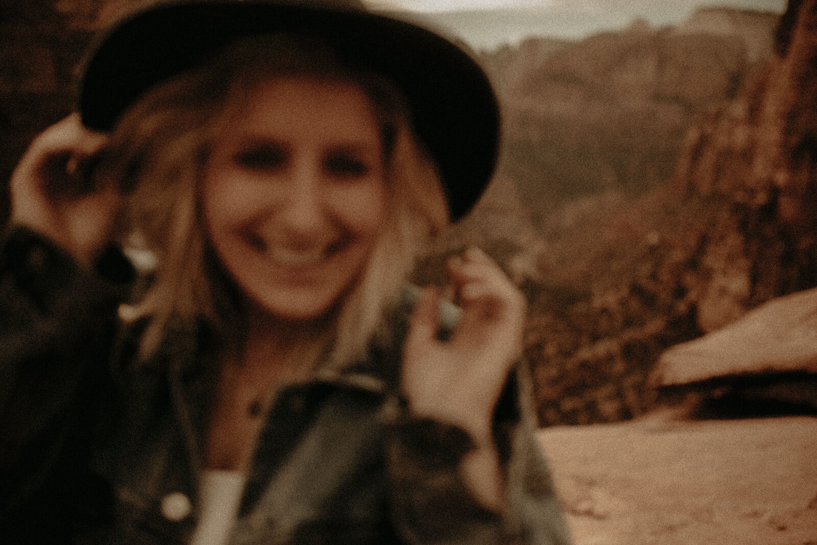 woman holding camera and backpack walking in desert