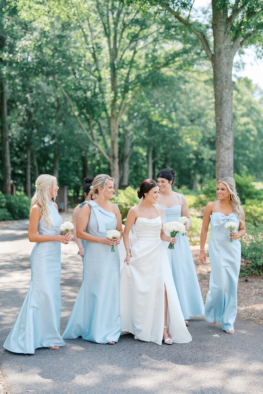 bridesmaids in blue dresses and bride walking at hadden estate in athens georgia  