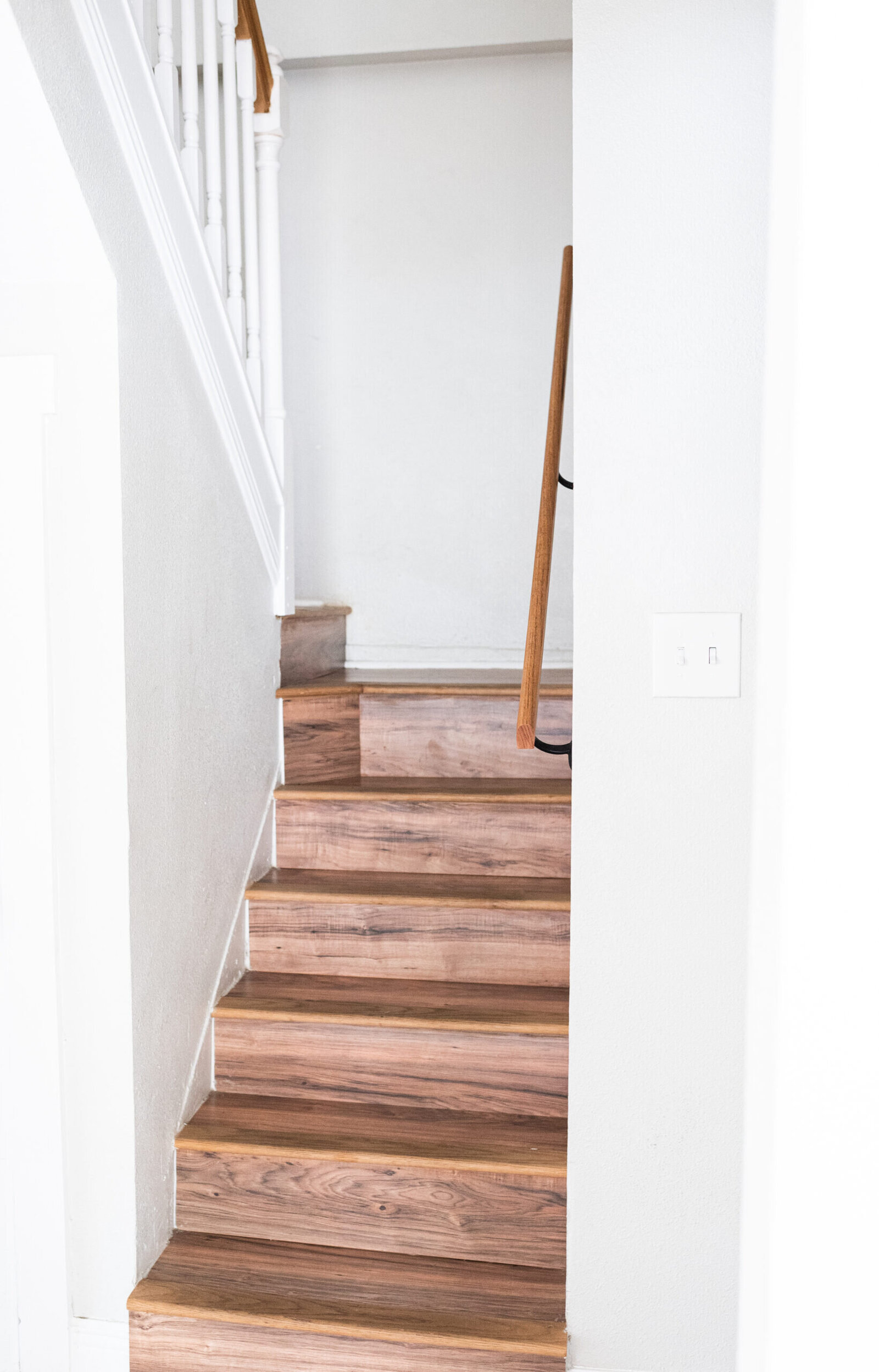 Staircase with wooden steps and white walls in a home