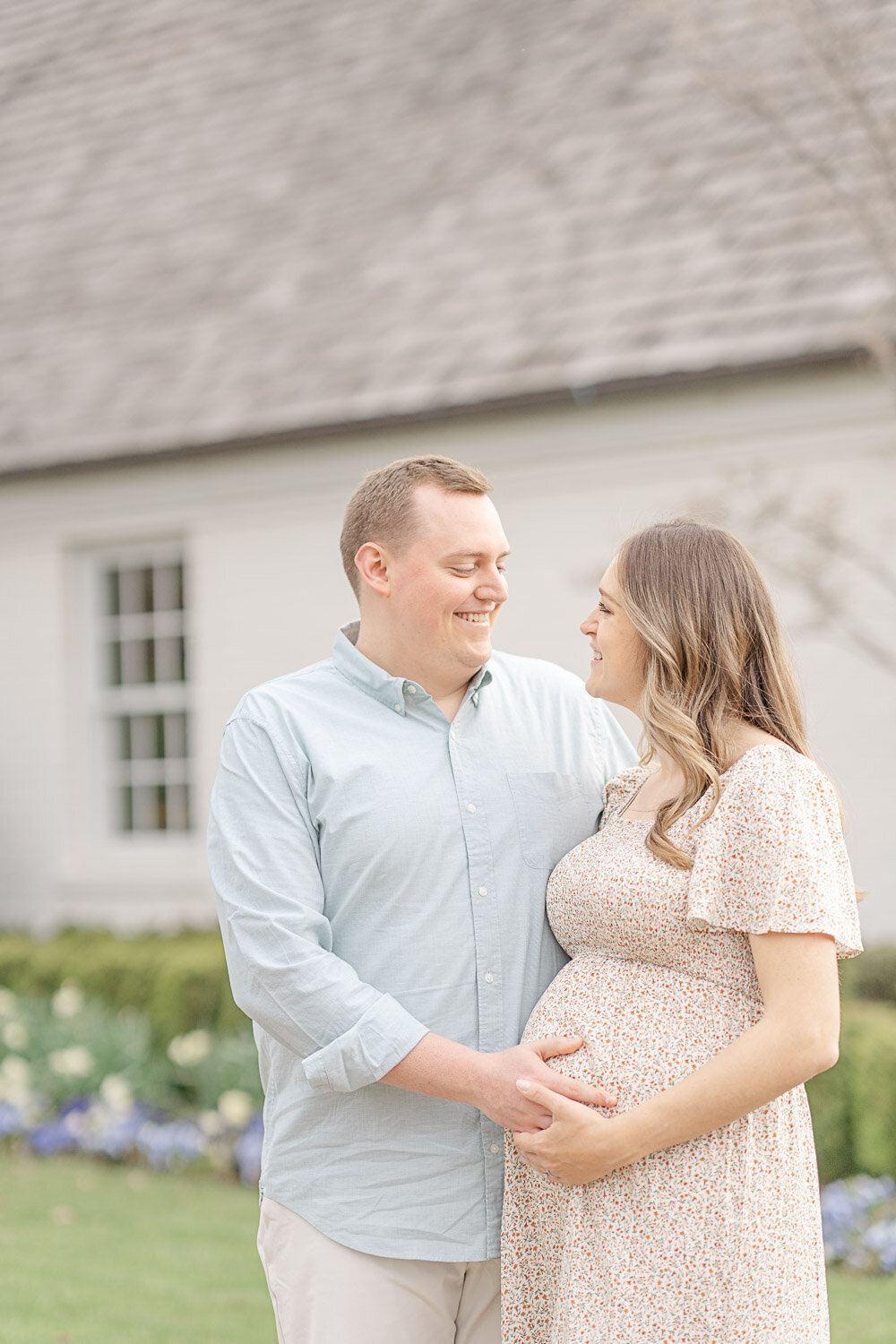 parents look at each other smiling during Ashburn, VA maternity picture