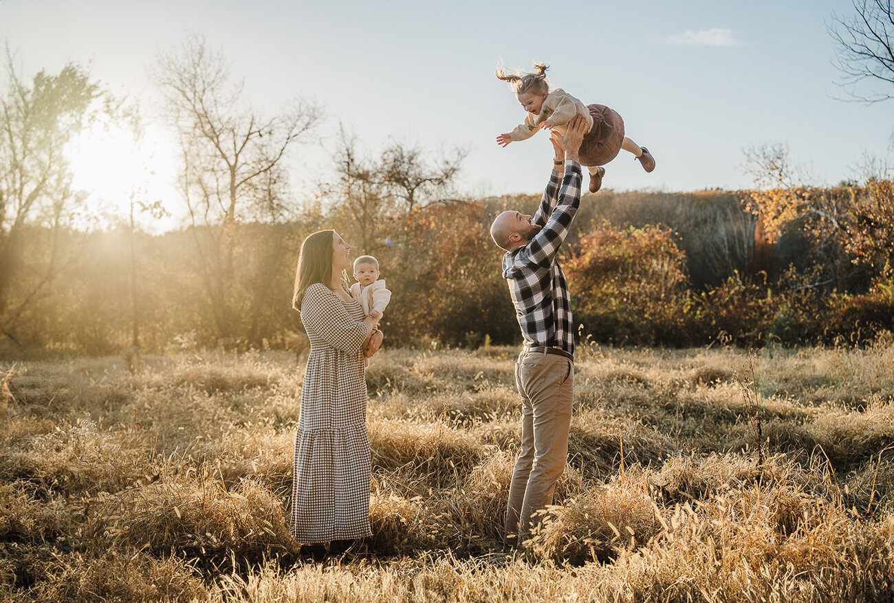 wide image of fall landscape with family of four in boston