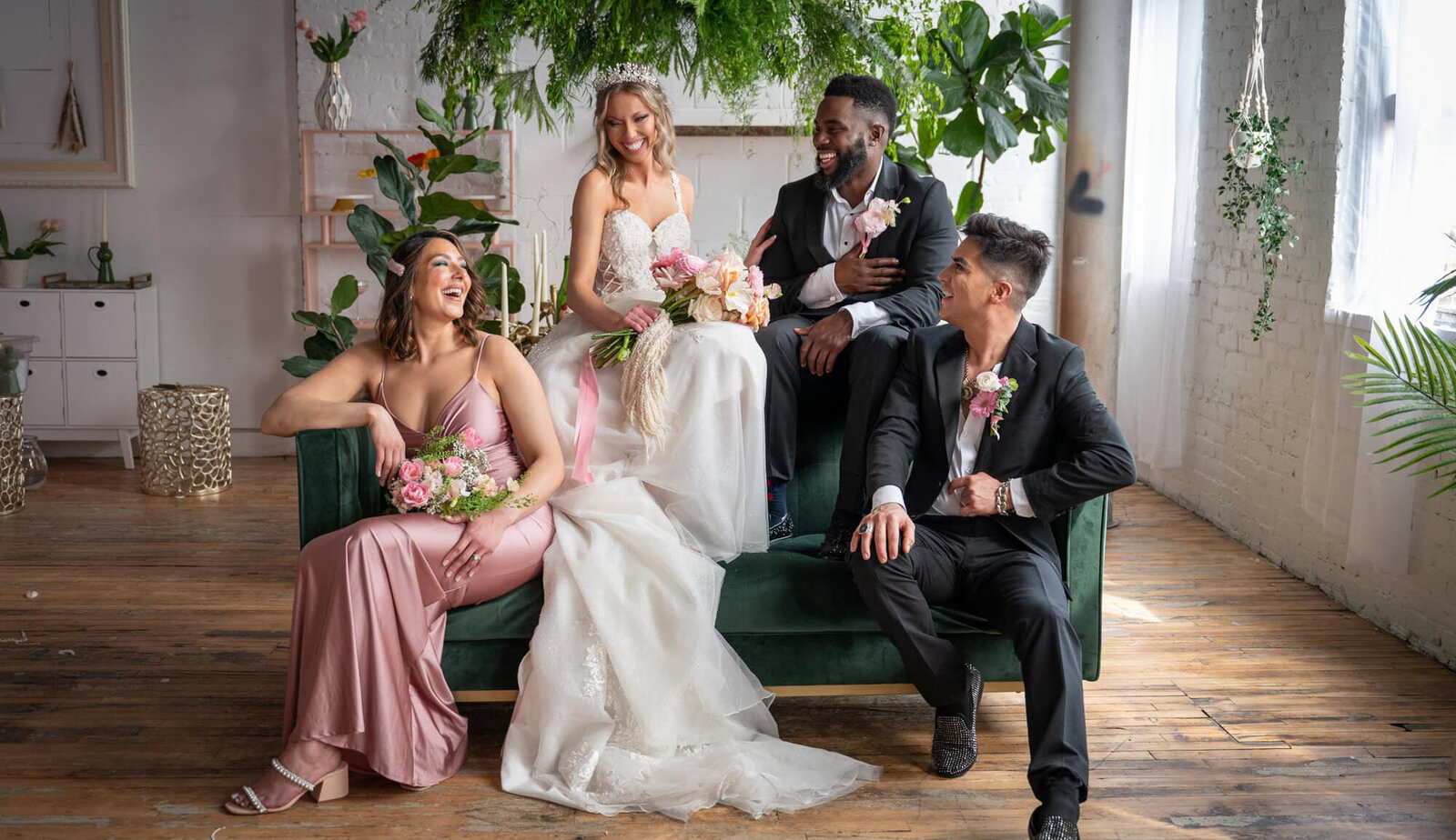 wedding party laughs together on green couch