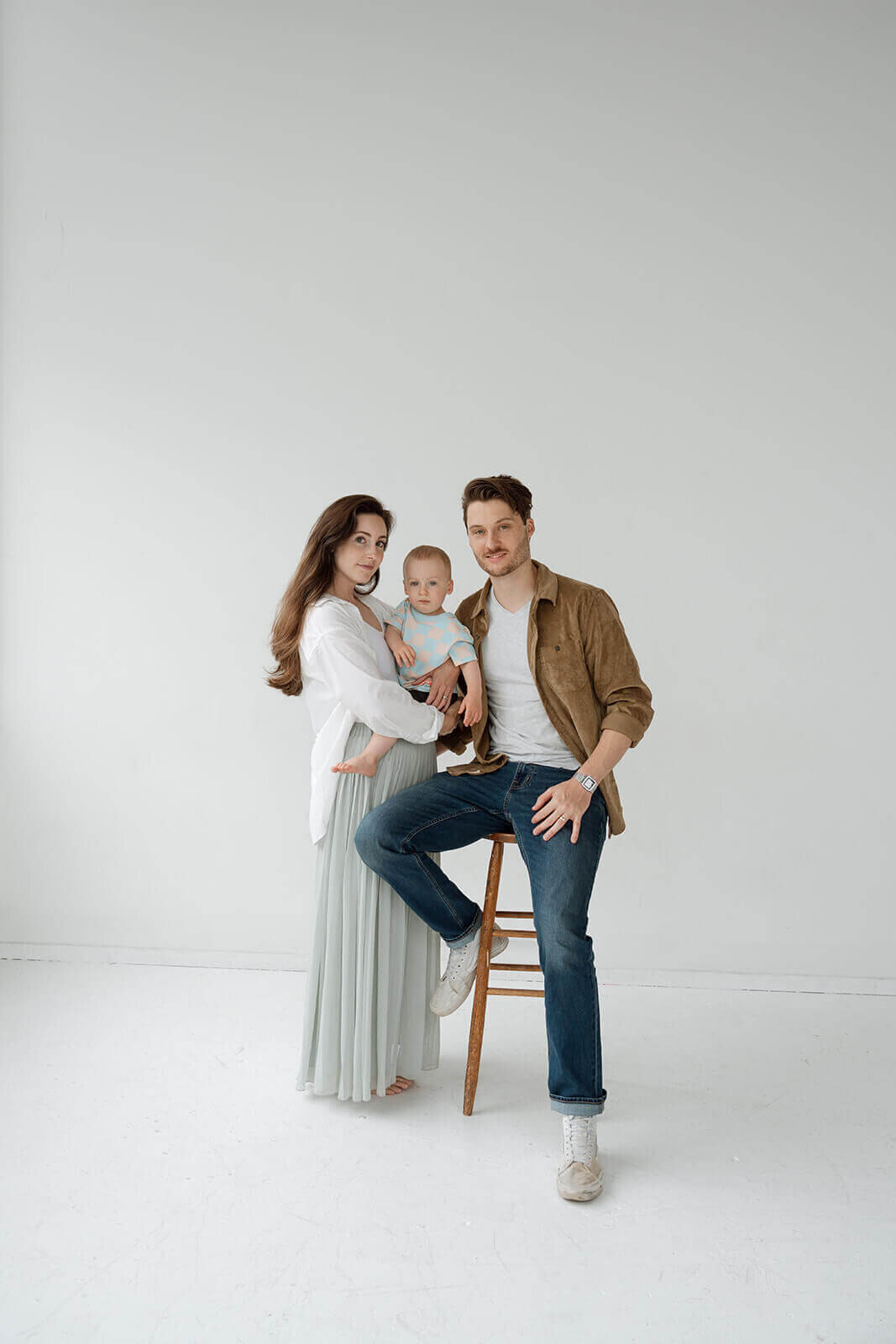 family of three portrait in all white photo studio california