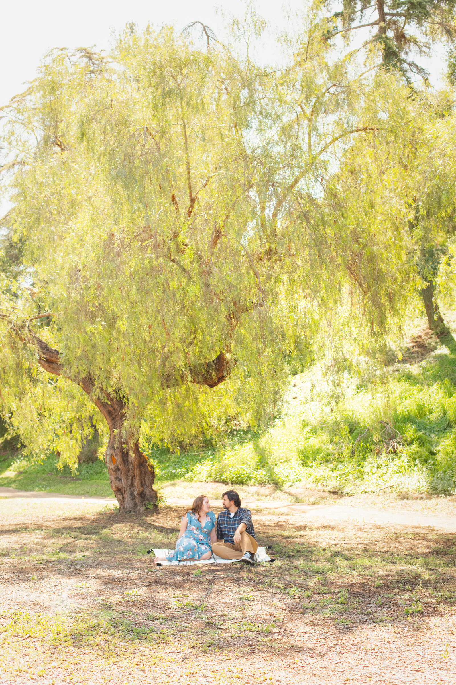 An engaged couple poses for photos in a garden in Los Angeles, Ca.