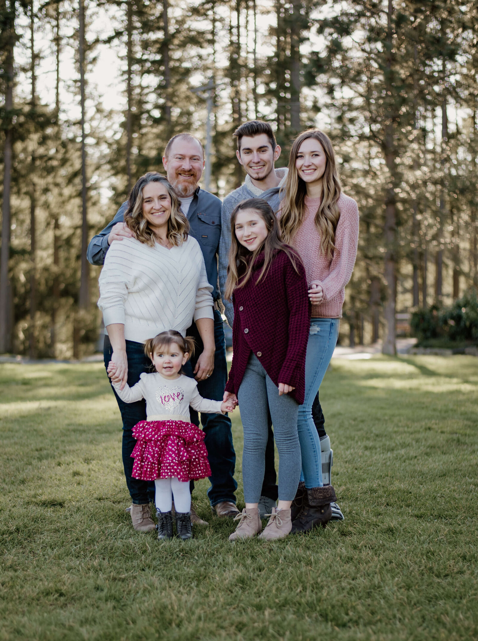 Family standing together in a field.