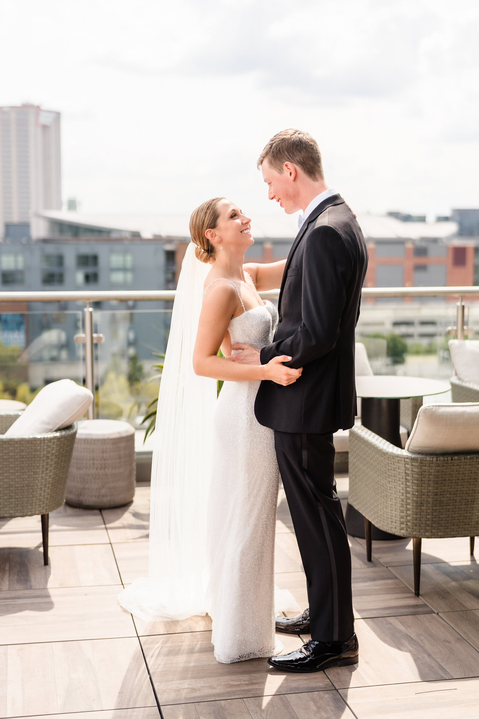 Bride and groom embrace on the rooftop balcony of the AC Marriott in downtown columbus