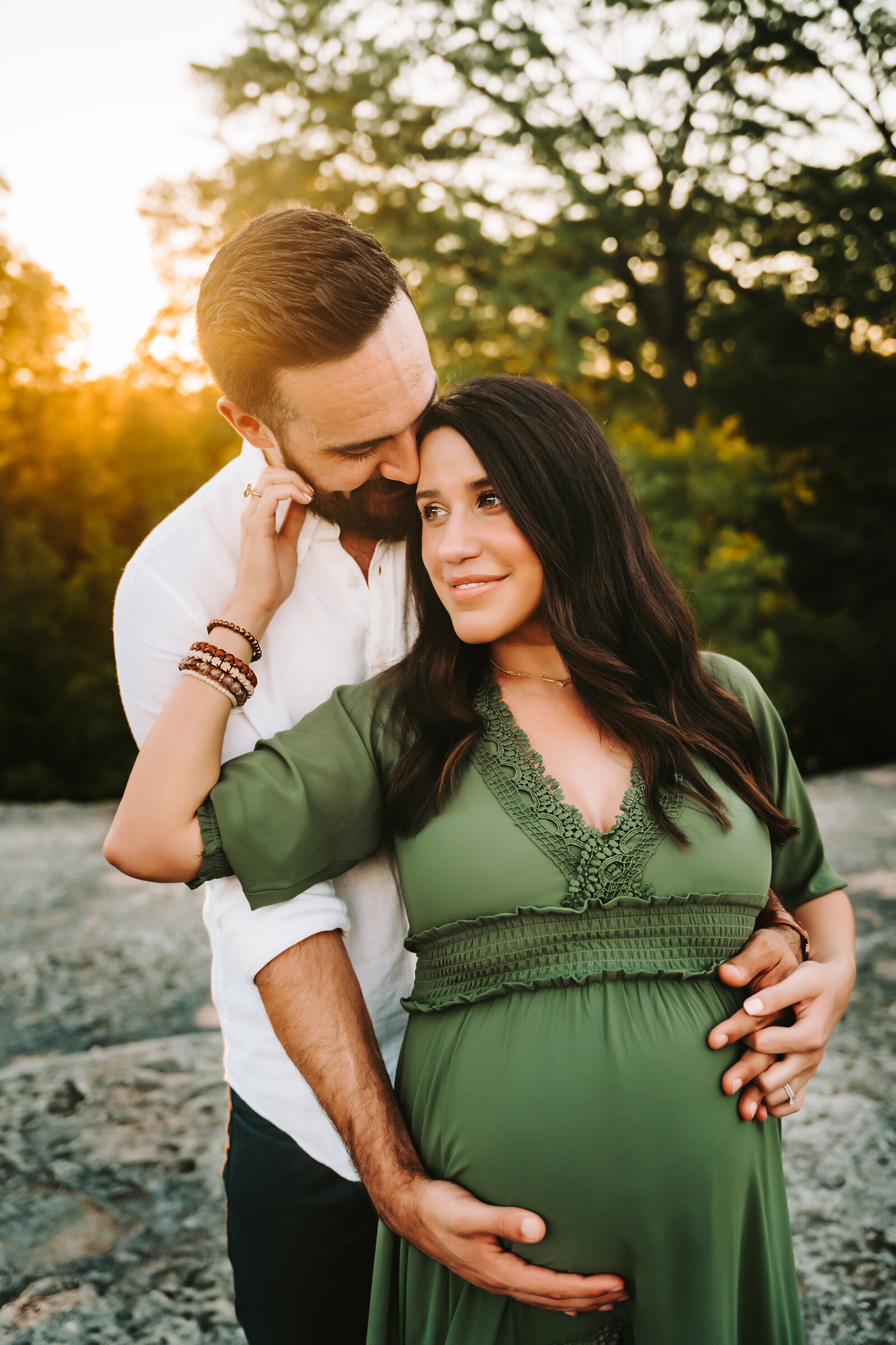Maternity Photographer, husband and wife embrace, she is pregnant, his hands in her belly, her hands on his face