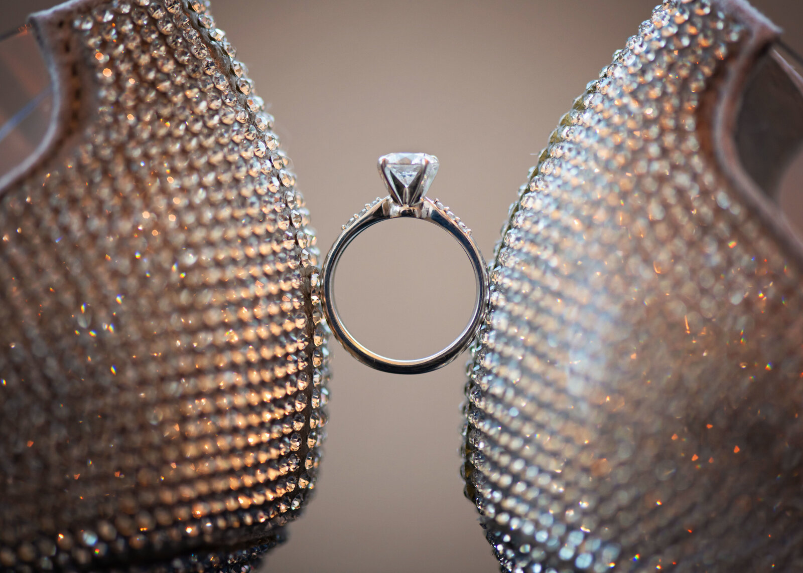 High end shot of sparkling Louboutin shoes holding up an engagement ring.