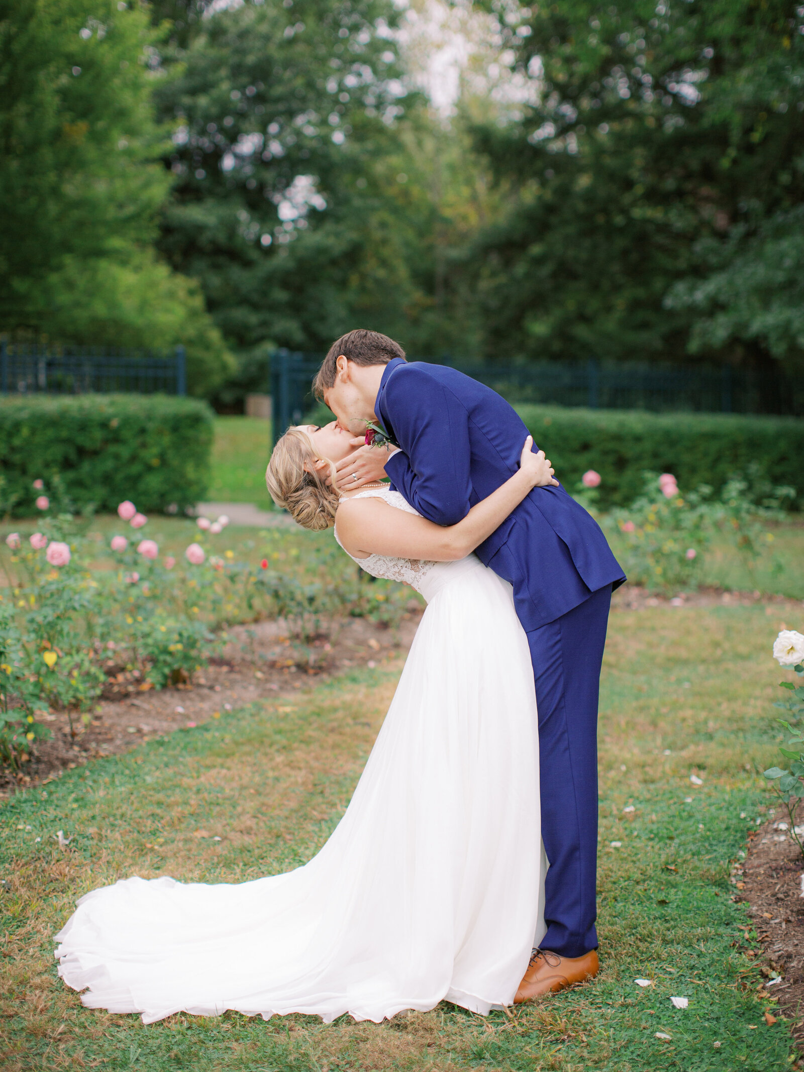 groom dips bride at mooreland mansion rose garden