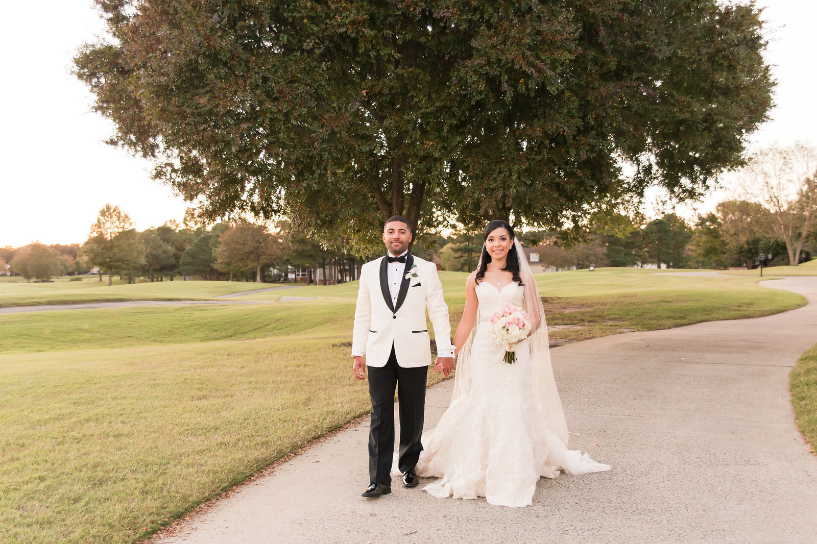 Bride and groom walking along a path at the Dominion Club
