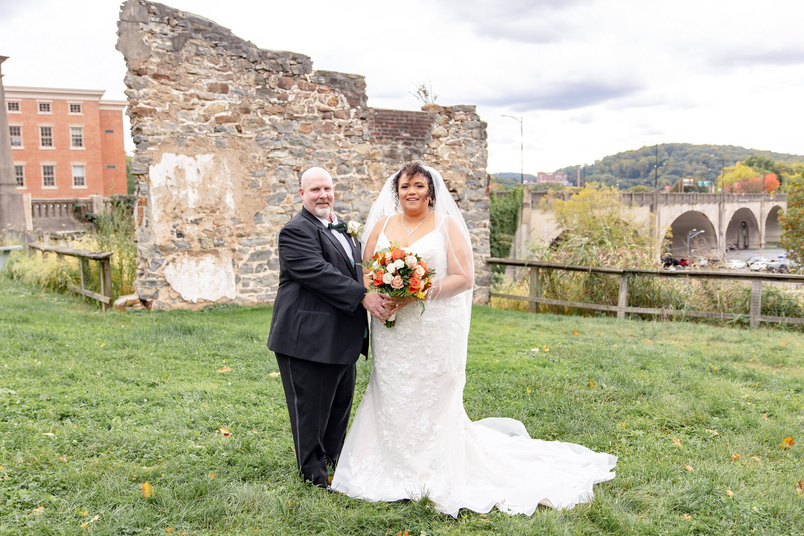 bride and groom outside with bridge in background