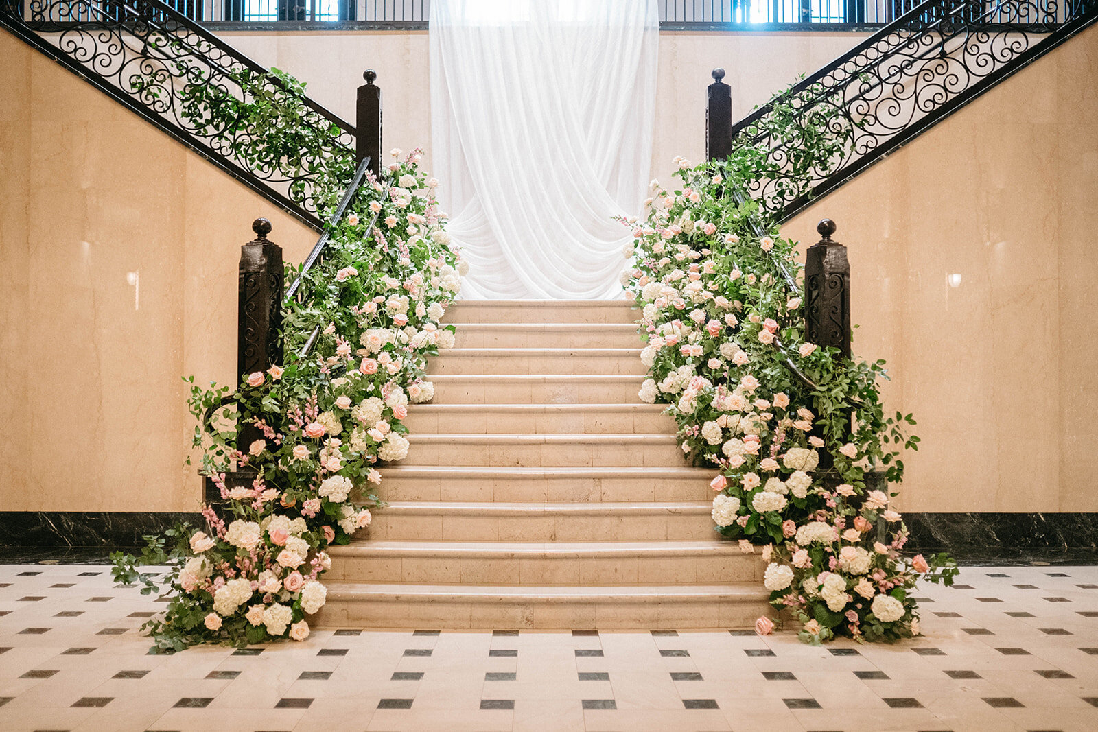 A floral installation on the ground cascades up a staircase at the Mayo Hotel in Tulsa. Floral design by Anthousai
