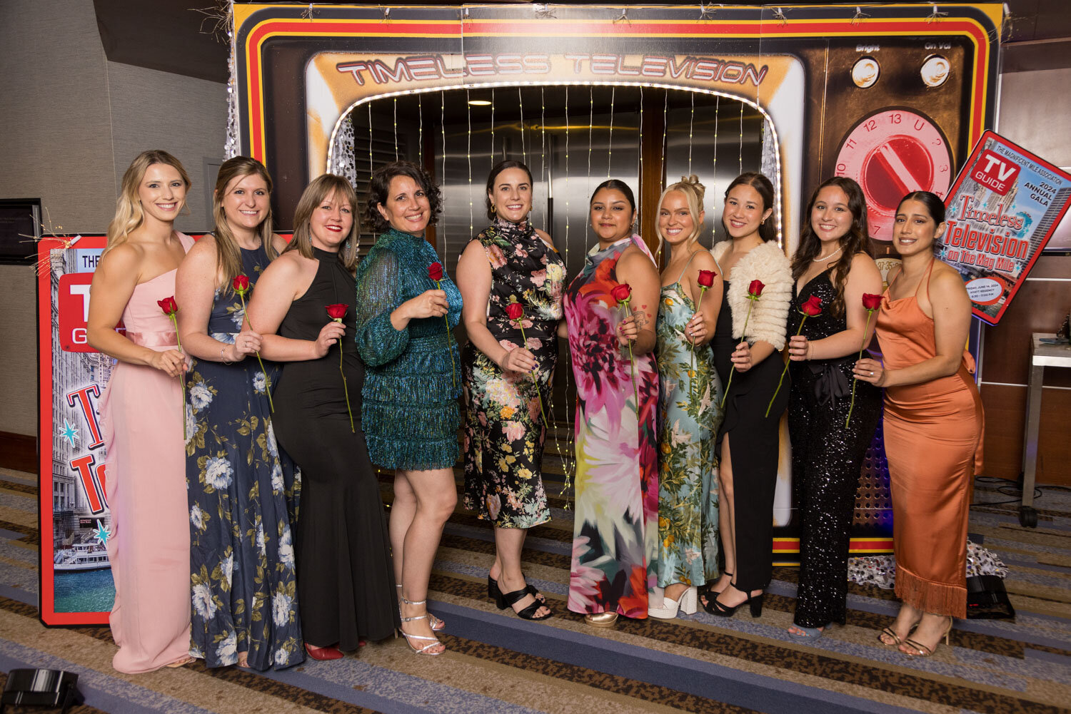 Group of people holding roses during a gala night