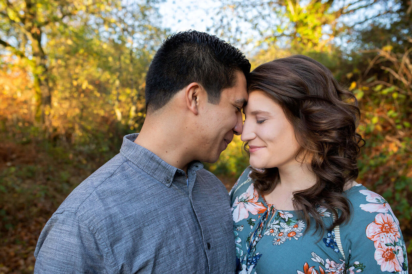 A close-up of a couple touching foreheads and smiling.