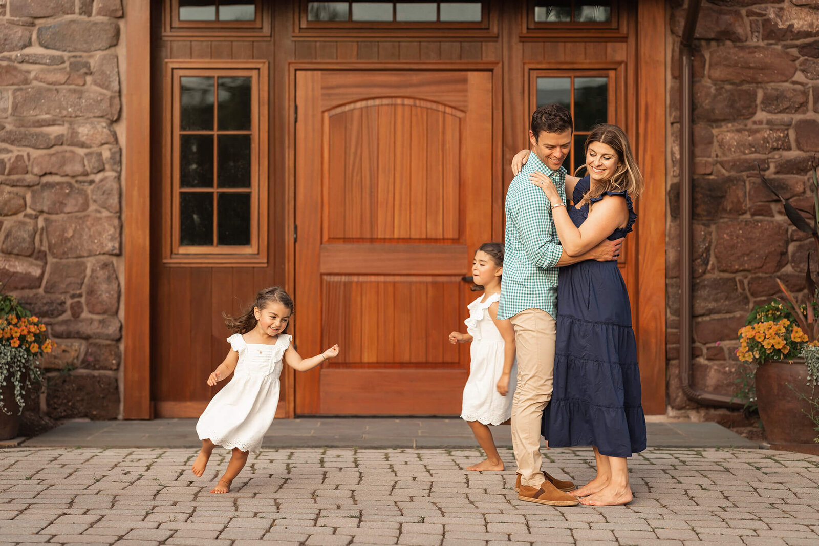 Parents stand together while their kids run circles around them