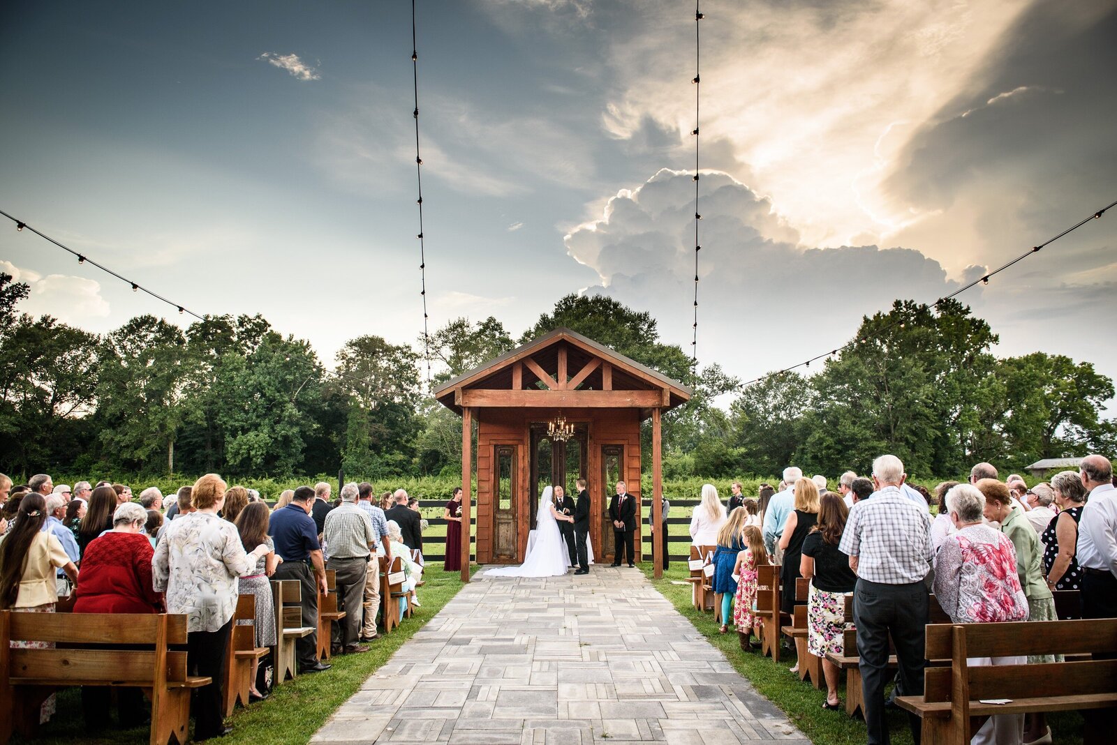Wedding ceremony at Berry Barn with dramatic sky in background