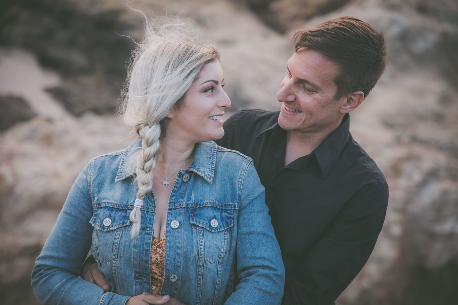 Couple smiles and stares at each other in Big Sur.