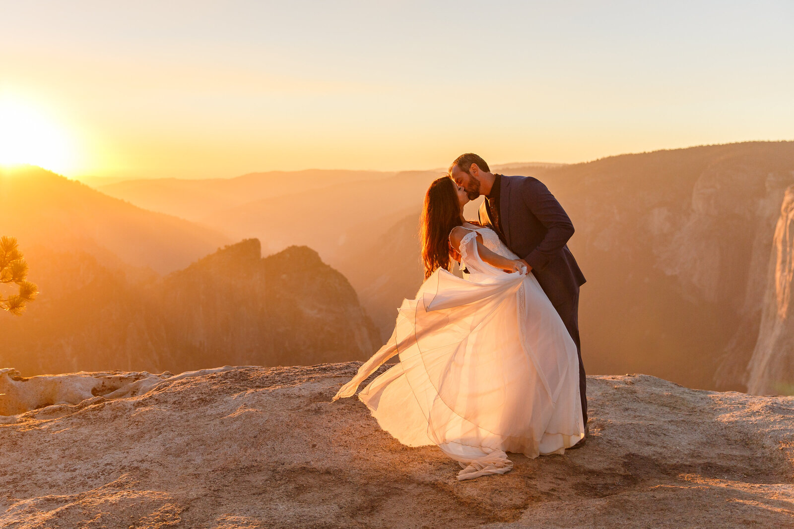 bride and groom kissing at sunset at taft point yosemite