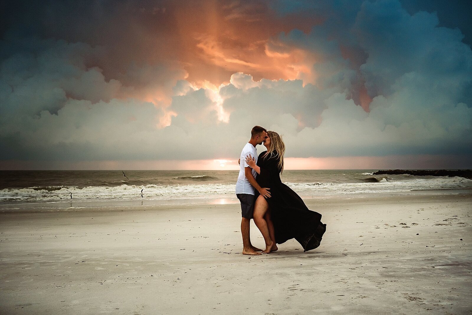 couple on clearwater beach during a storm at sunset