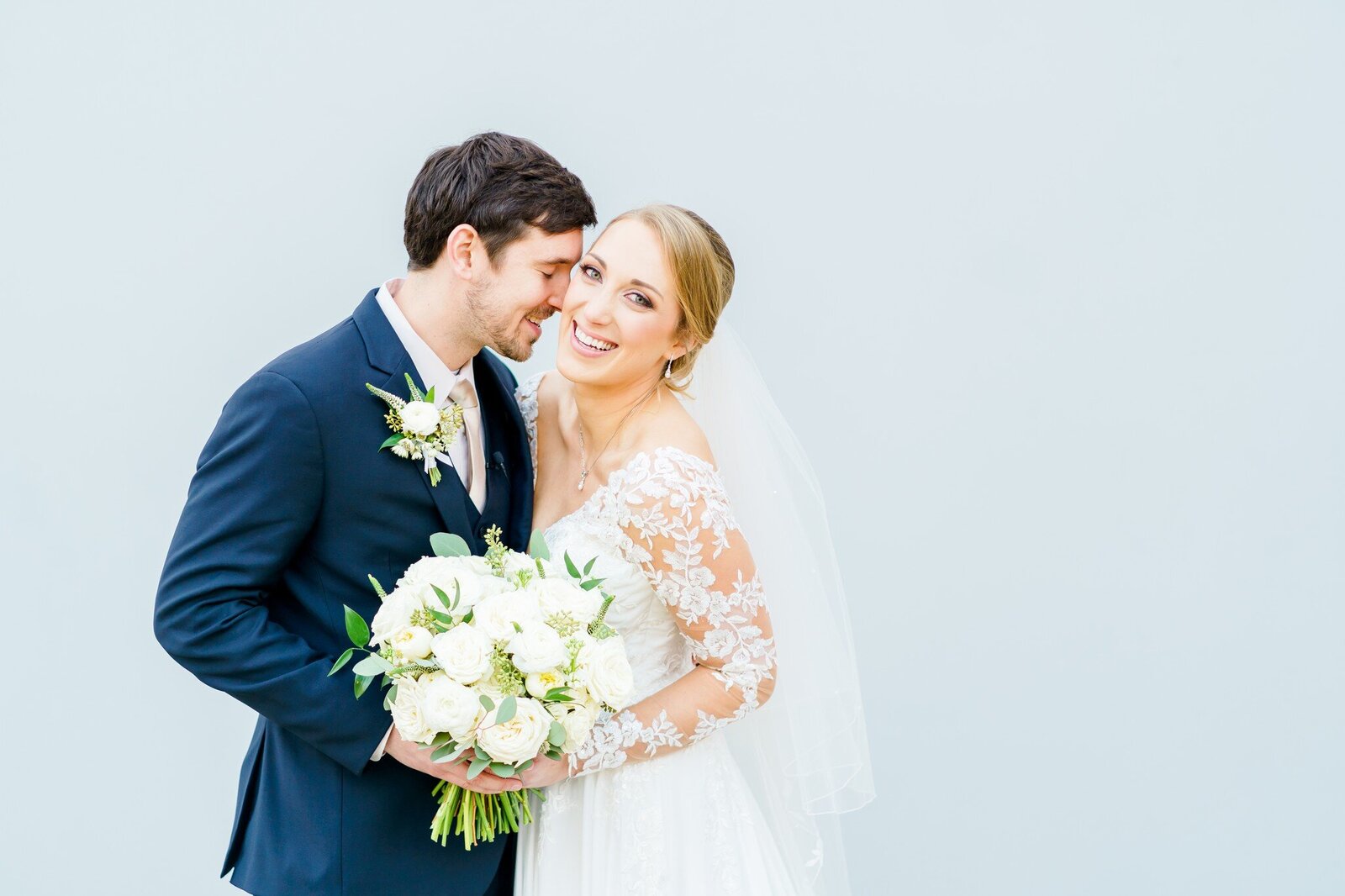 NH couple smiling with white bouquet