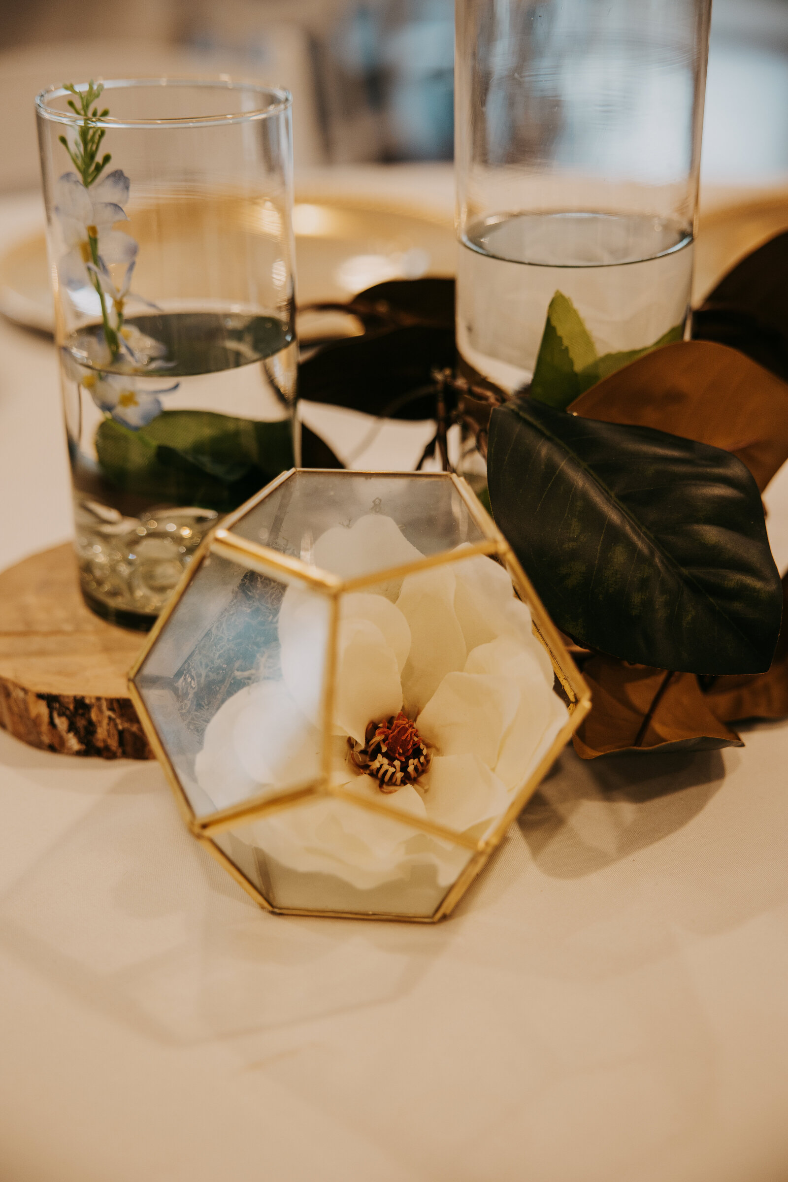 Table set up in the reception hall at Kincaid Manor, with a flower in a vase placed on a wooden base.