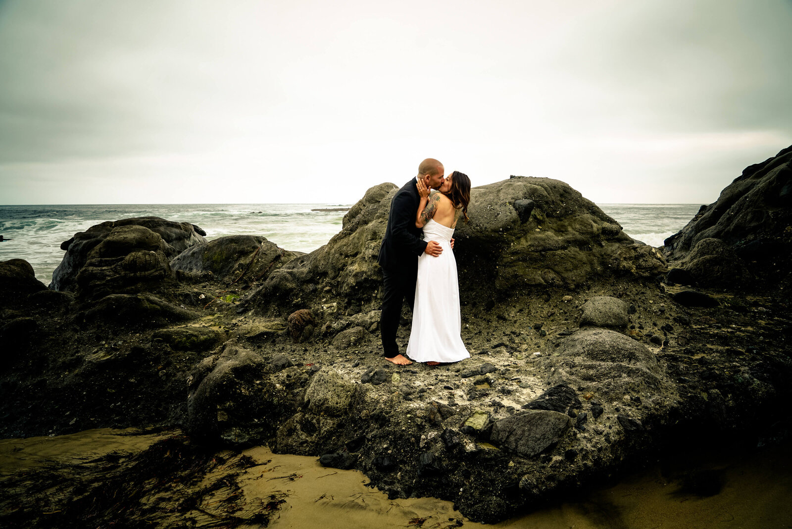 KS Gray Photography Newport Beach Bride and groom on rocks on the beach