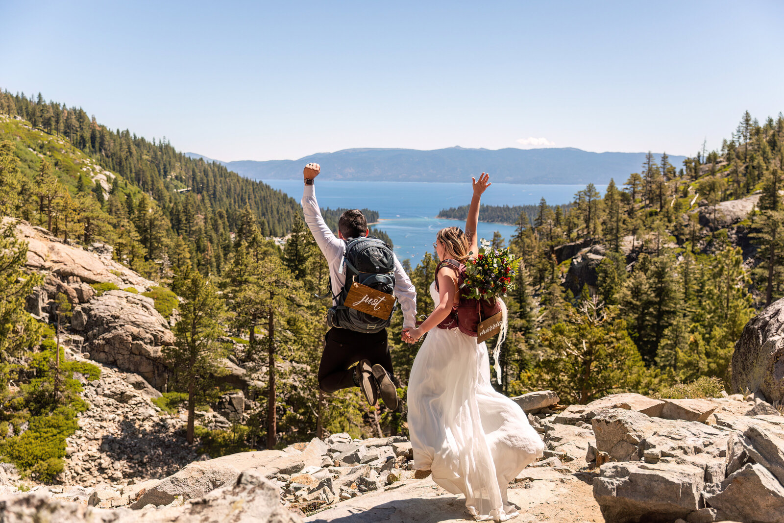 wedding couple jumping with emerald bay lake tahoe in the background