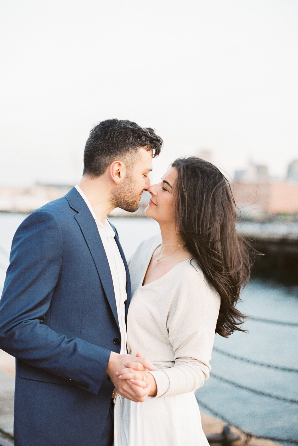 Couple holding hands as they are about to kiss.