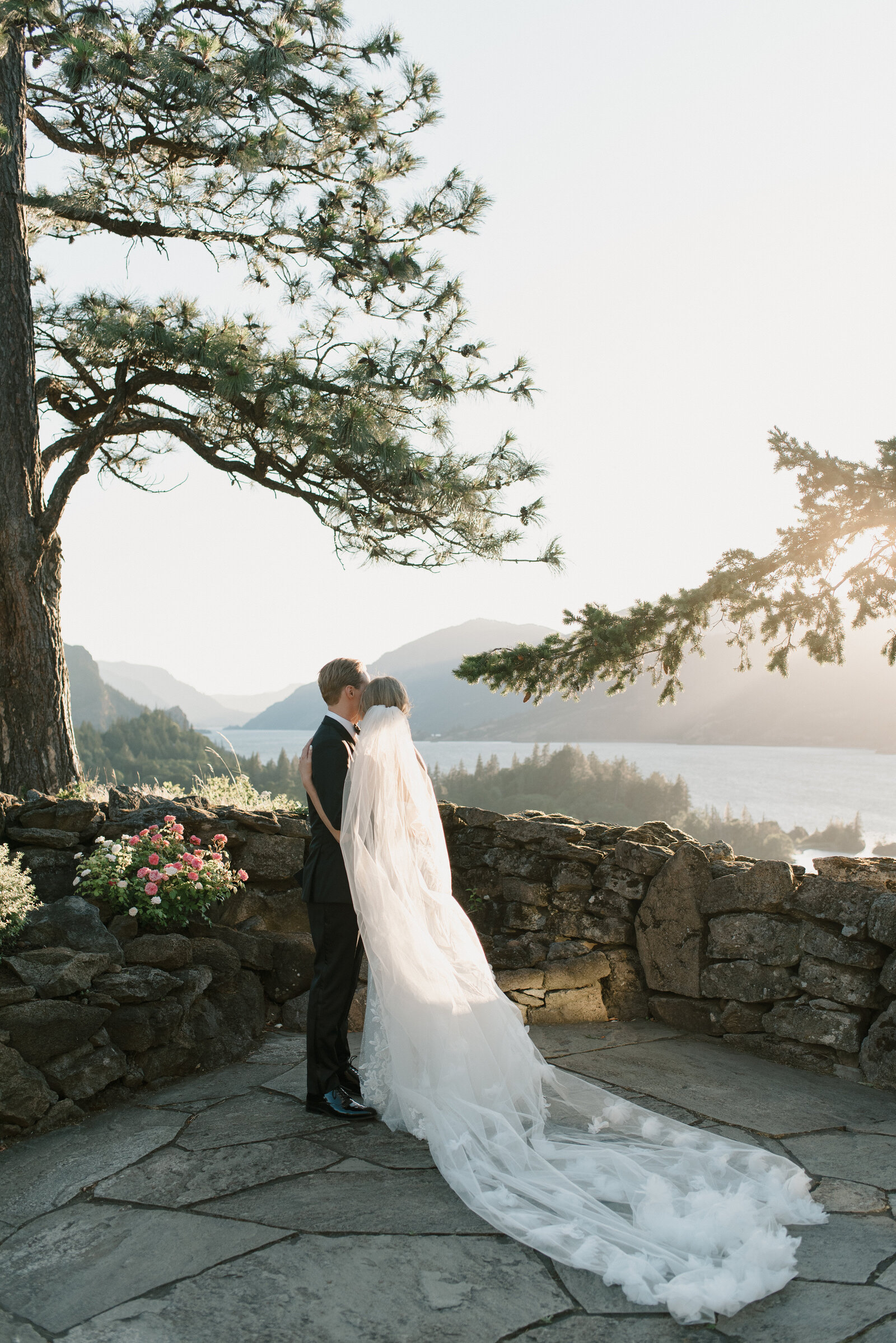 bride and groom overlooking the columbia river gorge with a long veil