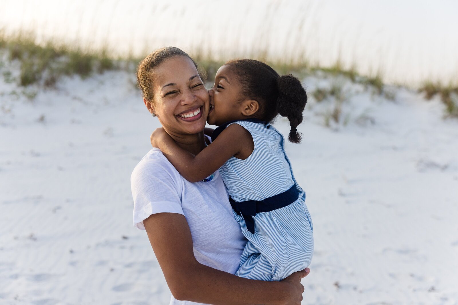Daughter giving mom a kiss prompt during Pensacola Beach photo session by Jennifer Beal Photography