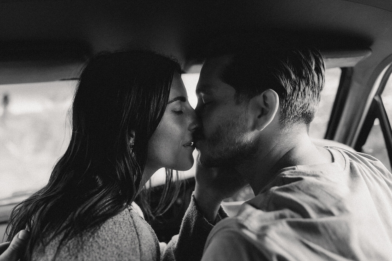 Intimate black and white photo of a couple sharing a moment in a car with Sunshine Coast photographer