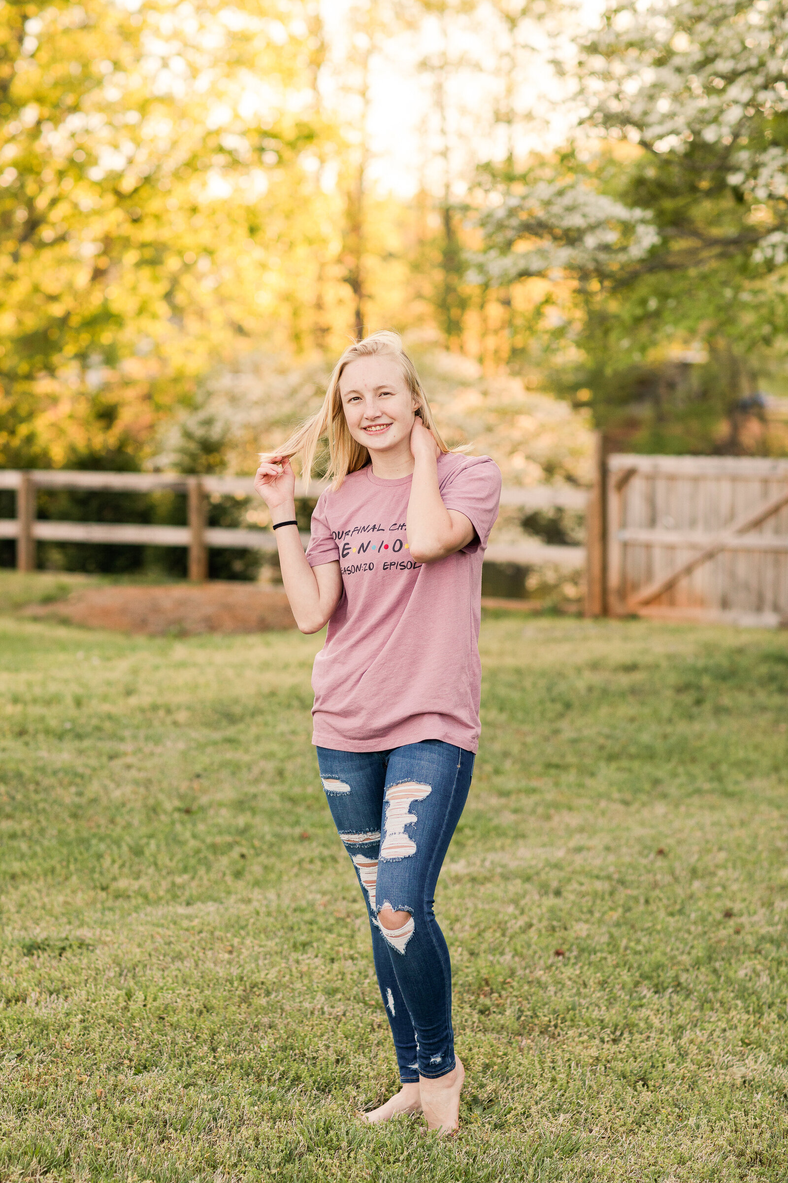 senior girl in tee shirt and jeans in a field