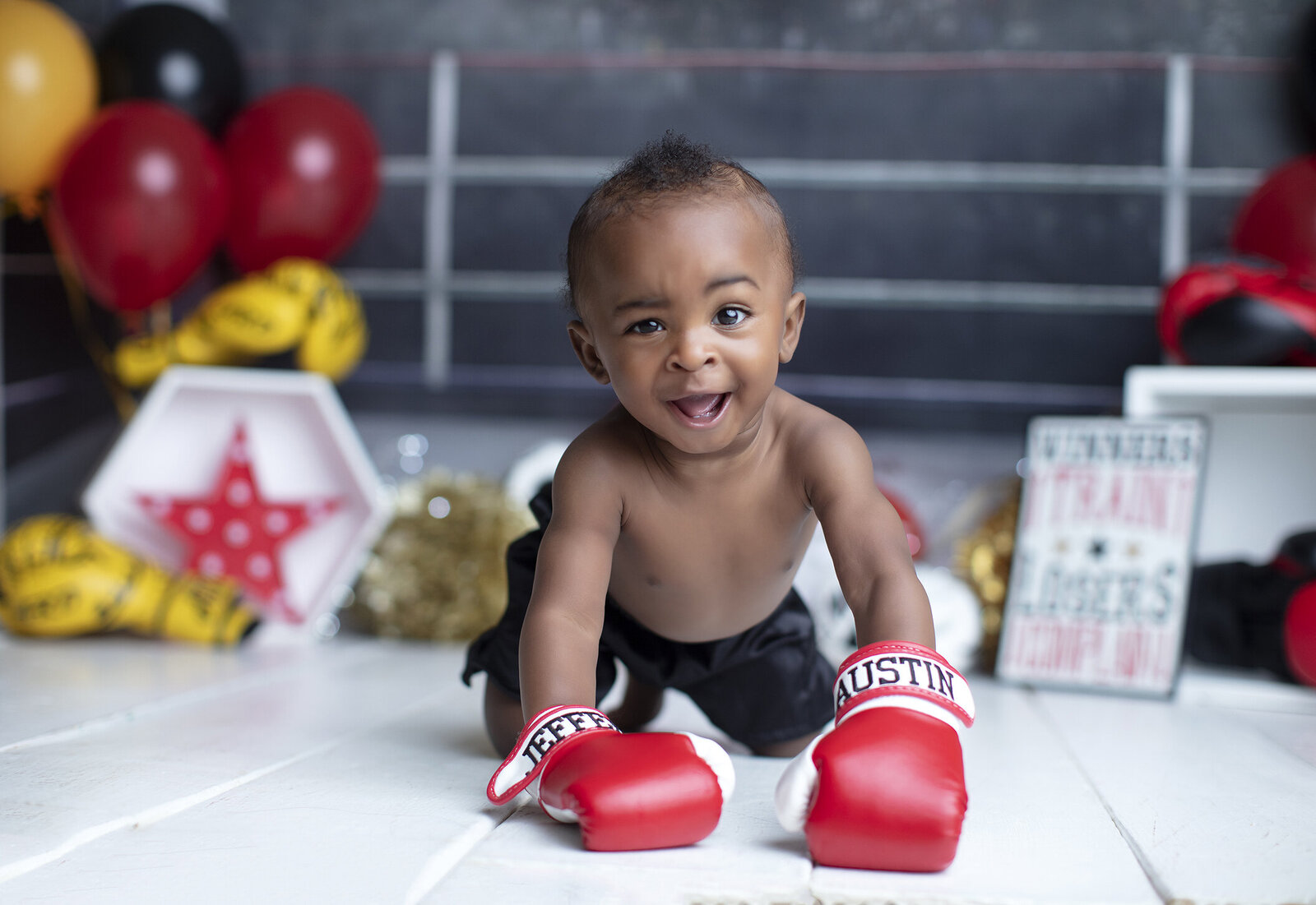 Boy makes funny face at boxing themed cake smash.