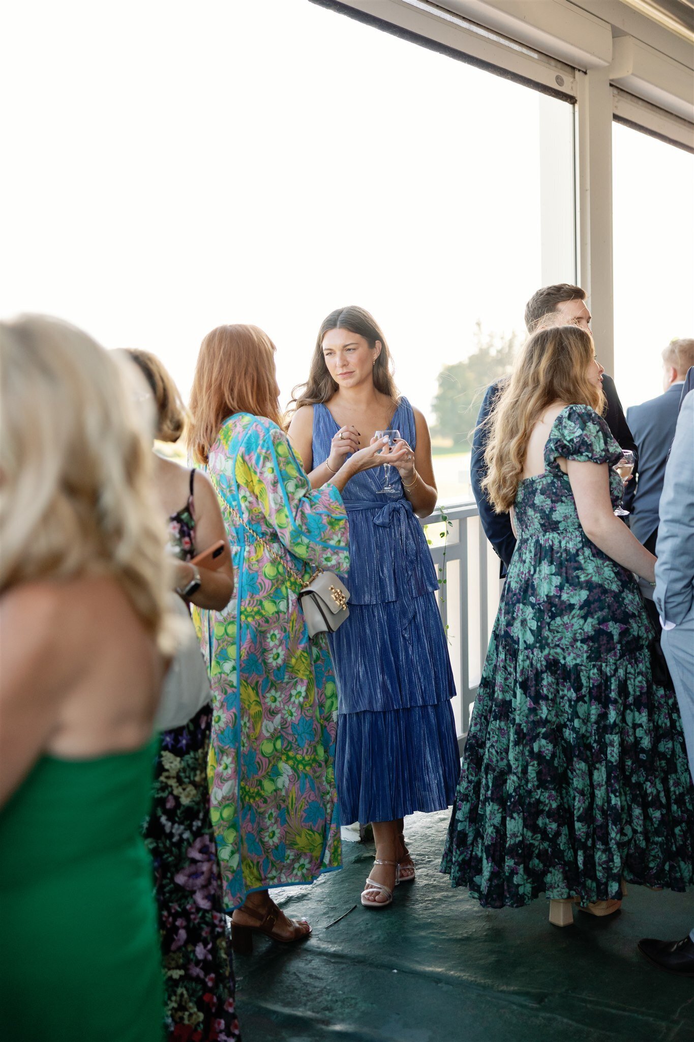 Guests at a cocktail hour mingling on the porch of Mission Point Resort