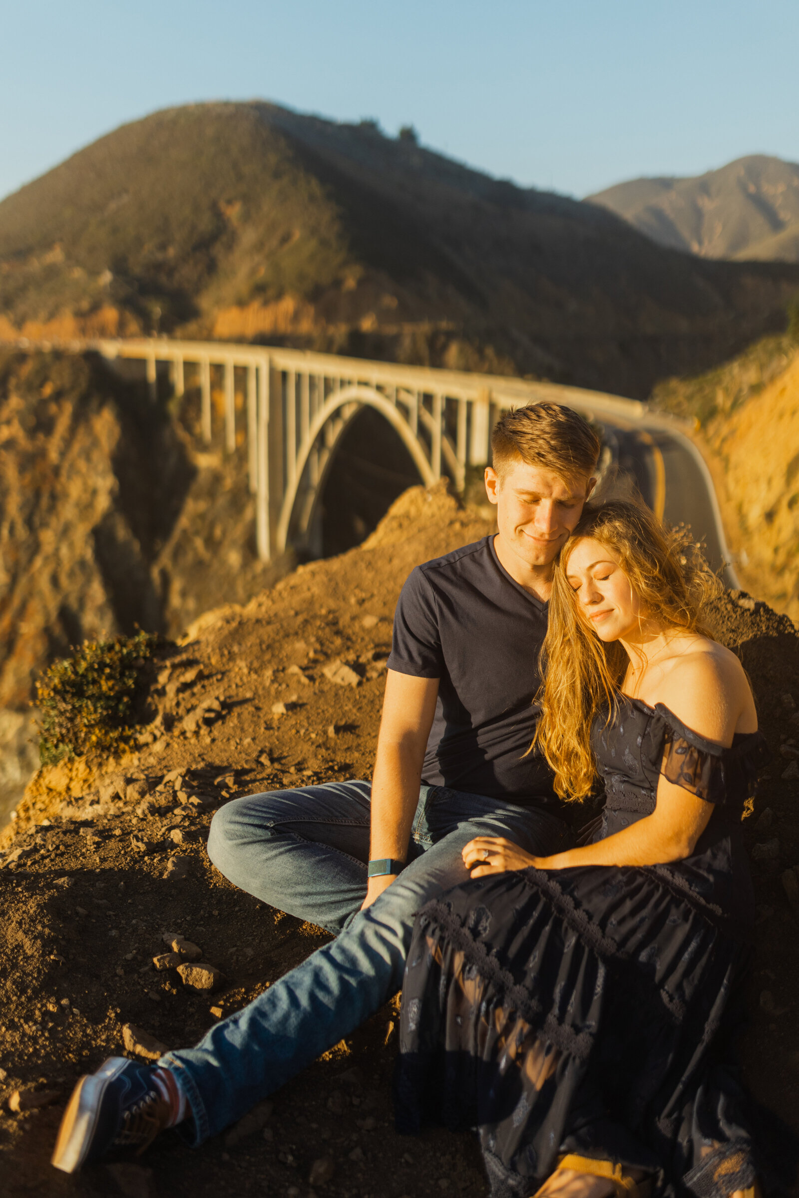 A couple poses for their engagement photos in Big Sur, California.
