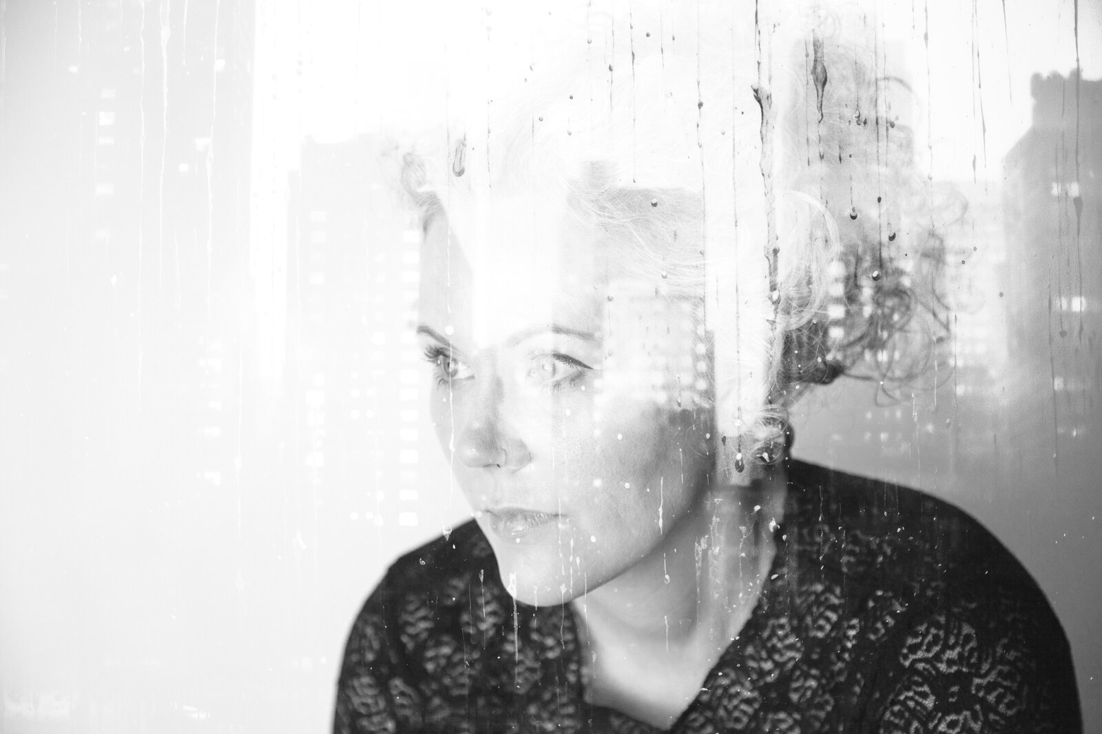 Double exposure of woman's face and cityscape.