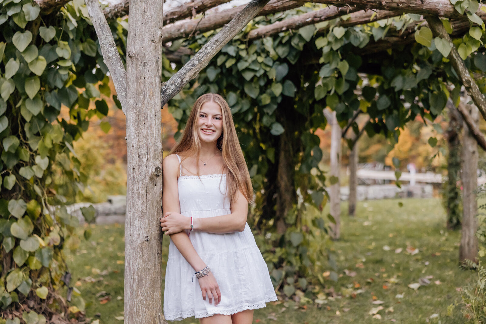 high school senior girl smiling at camera in white dress