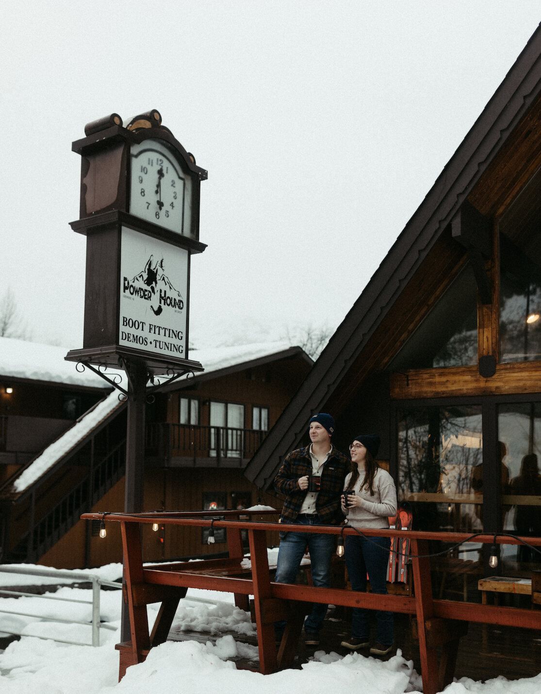 Couple drinking coffee off a porch with snow on the ground